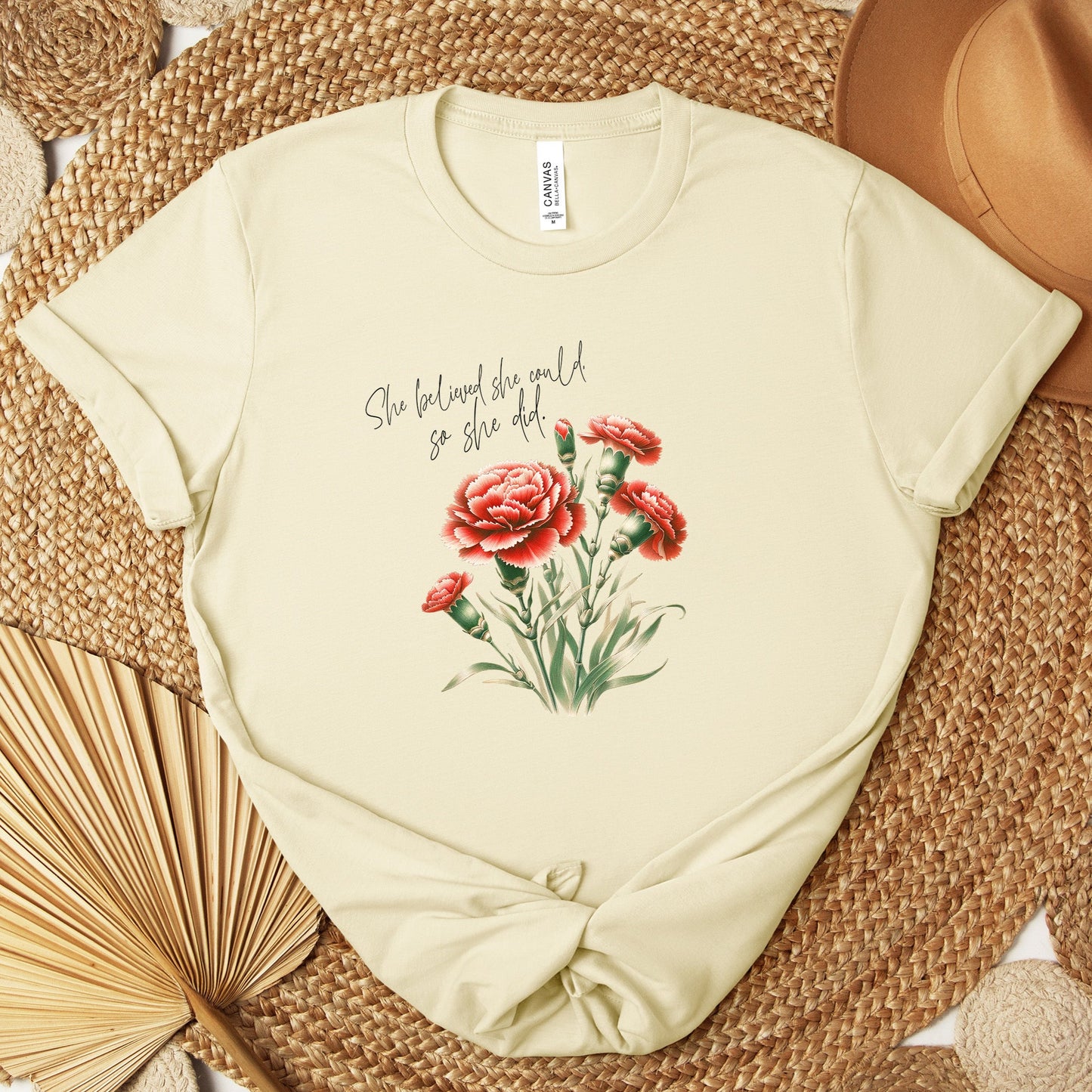 A t-shirt featuring a beautiful carnation for January with the quote “She believed she could, so she did.” Perfect for January birthdays and floral art lovers. Comfortable and stylish for casual outings or celebrations. Bella+Canvas 3001 t-shirt in natural. ReadyShirtAim.com