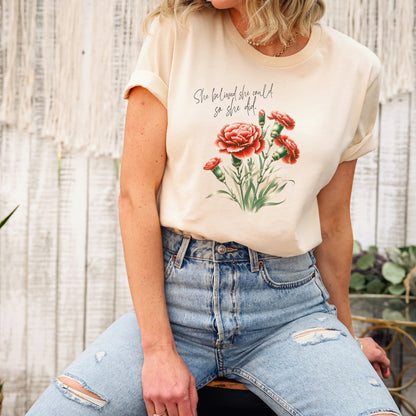 A t-shirt featuring a beautiful carnation for January with the quote “She believed she could, so she did.” Perfect for January birthdays and floral art lovers. Comfortable and stylish for casual outings or celebrations. Bella+Canvas 3001 t-shirt in soft cream. ReadyShirtAim.com