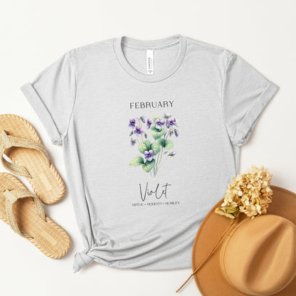 A t-shirt featuring a beautiful violet for February with traits Virtue, Modesty, Humility. Perfect for February birthdays and floral art lovers. Comfortable and stylish for casual outings or celebrations. Bella+Canvas 3001 t-shirt in ash. ReadyShirtAim.com