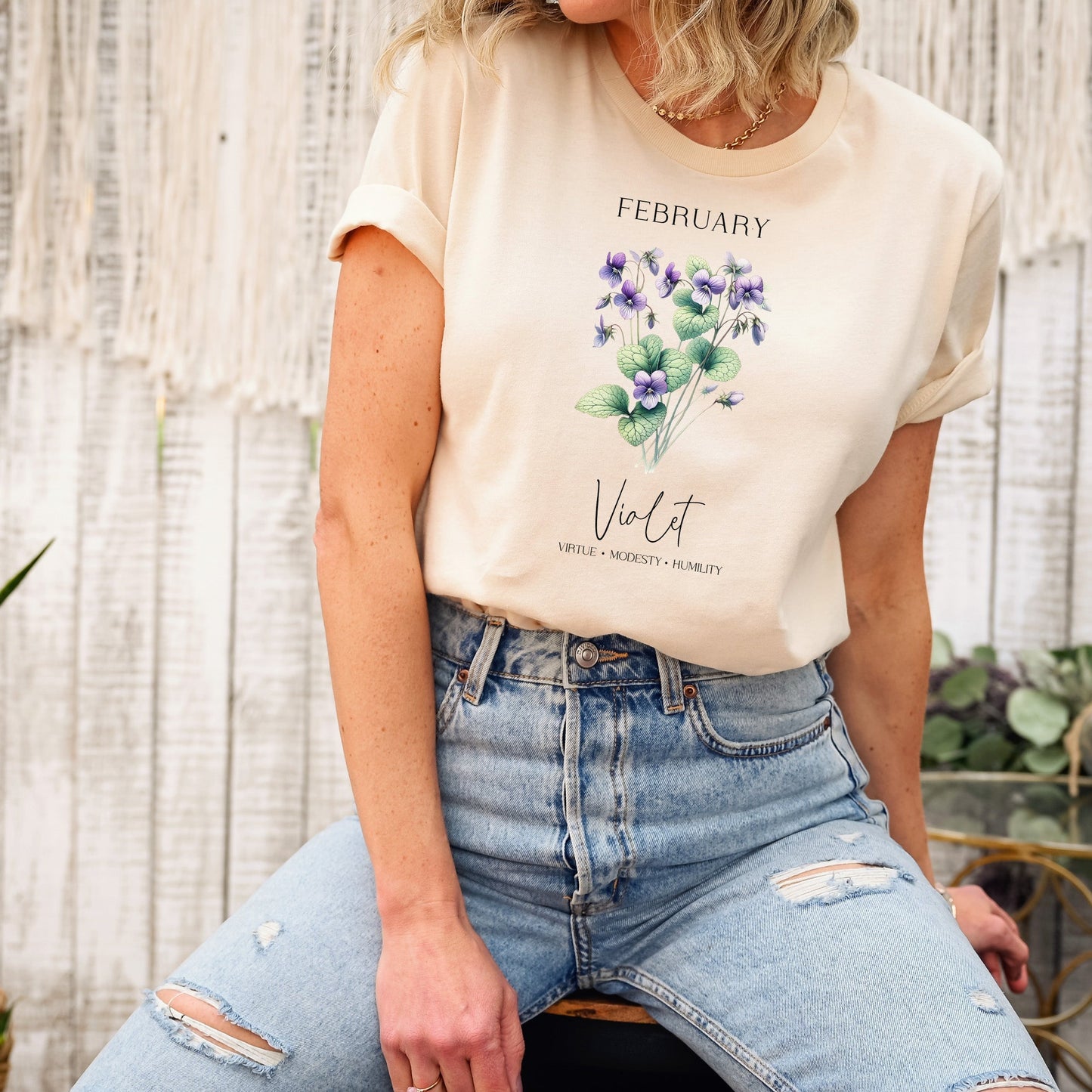 A t-shirt featuring a beautiful violet for February with traits Virtue, Modesty, Humility. Perfect for February birthdays and floral art lovers. Comfortable and stylish for casual outings or celebrations. Bella+Canvas 3001 t-shirt in soft cream. ReadyShirtAim.com