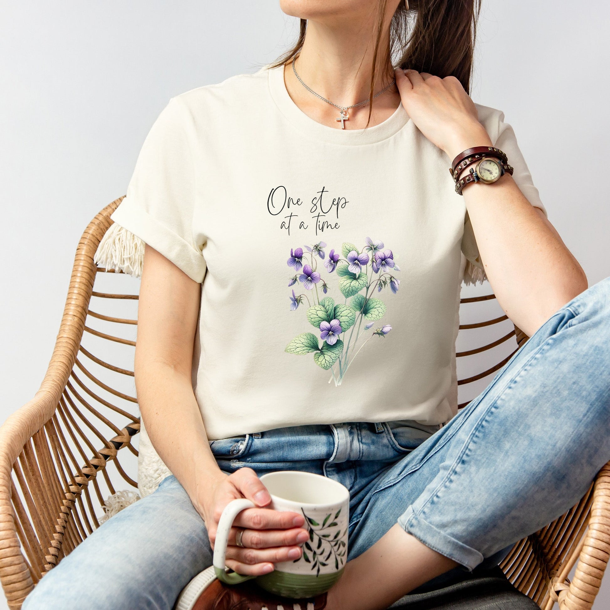 A t-shirt featuring a beautiful violet for February with the quote “One step at a time.” Perfect for February birthdays and floral art lovers. Comfortable and stylish for casual outings or celebrations. Bella+Canvas 3001 t-shirt in natural. ReadyShirtAim.com