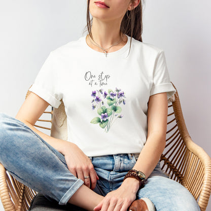 A t-shirt featuring a beautiful violet for February with the quote “One step at a time.” Perfect for February birthdays and floral art lovers. Comfortable and stylish for casual outings or celebrations. Bella+Canvas 3001 t-shirt in white. ReadyShirtAim.com