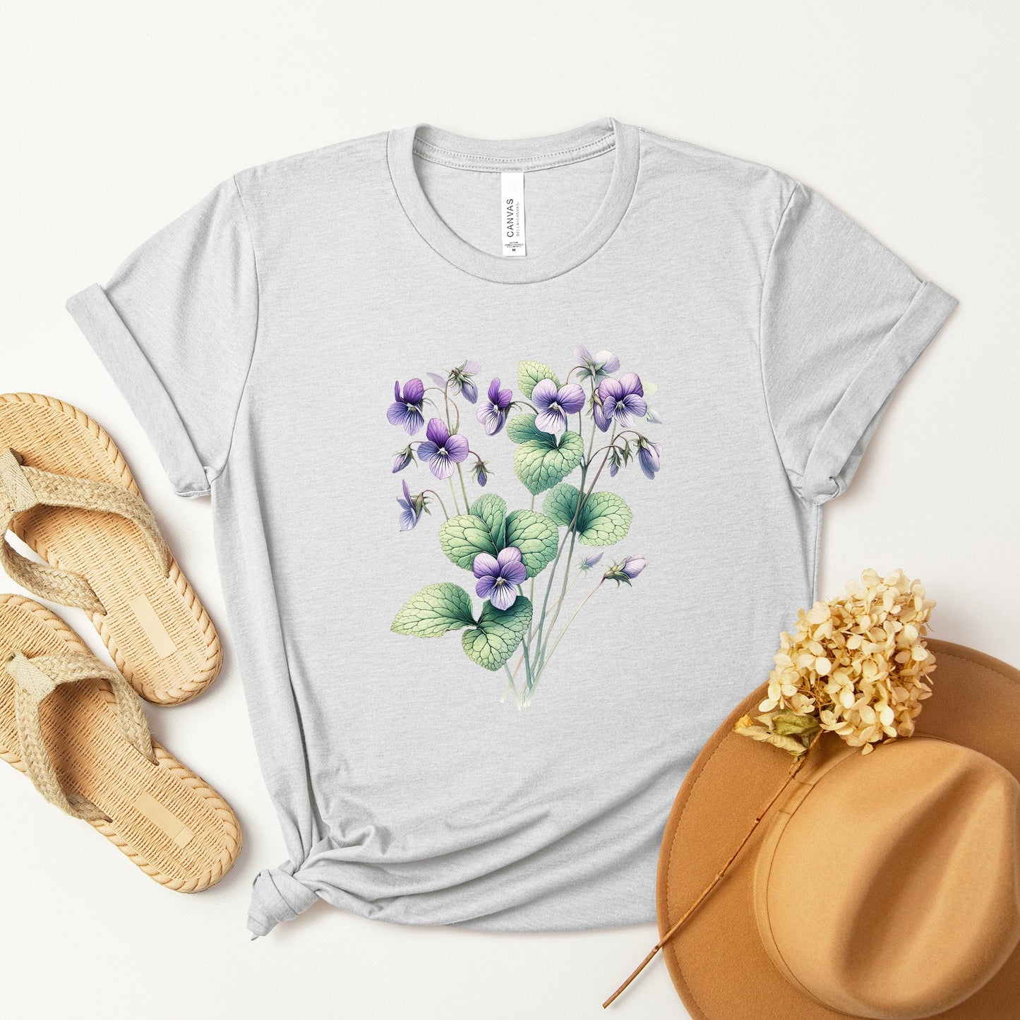 A t-shirt featuring a beautiful violet for February. Perfect for February birthdays and floral art lovers. Comfortable and stylish for casual outings or celebrations. Bella+Canvas 3001 t-shirt in ash. ReadyShirtAim.com