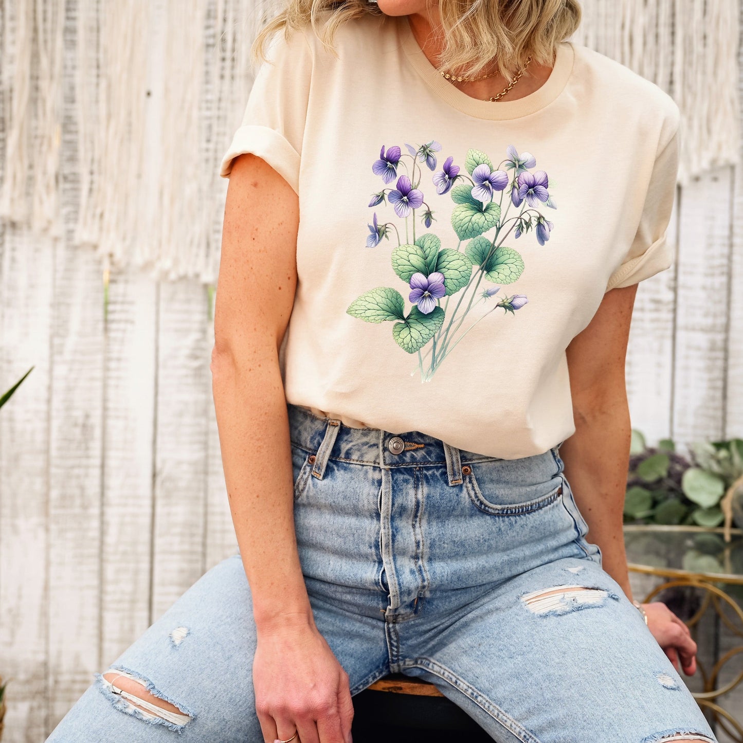 A t-shirt featuring a beautiful violet for February. Perfect for February birthdays and floral art lovers. Comfortable and stylish for casual outings or celebrations. Bella+Canvas 3001 t-shirt in soft cream. ReadyShirtAim.com