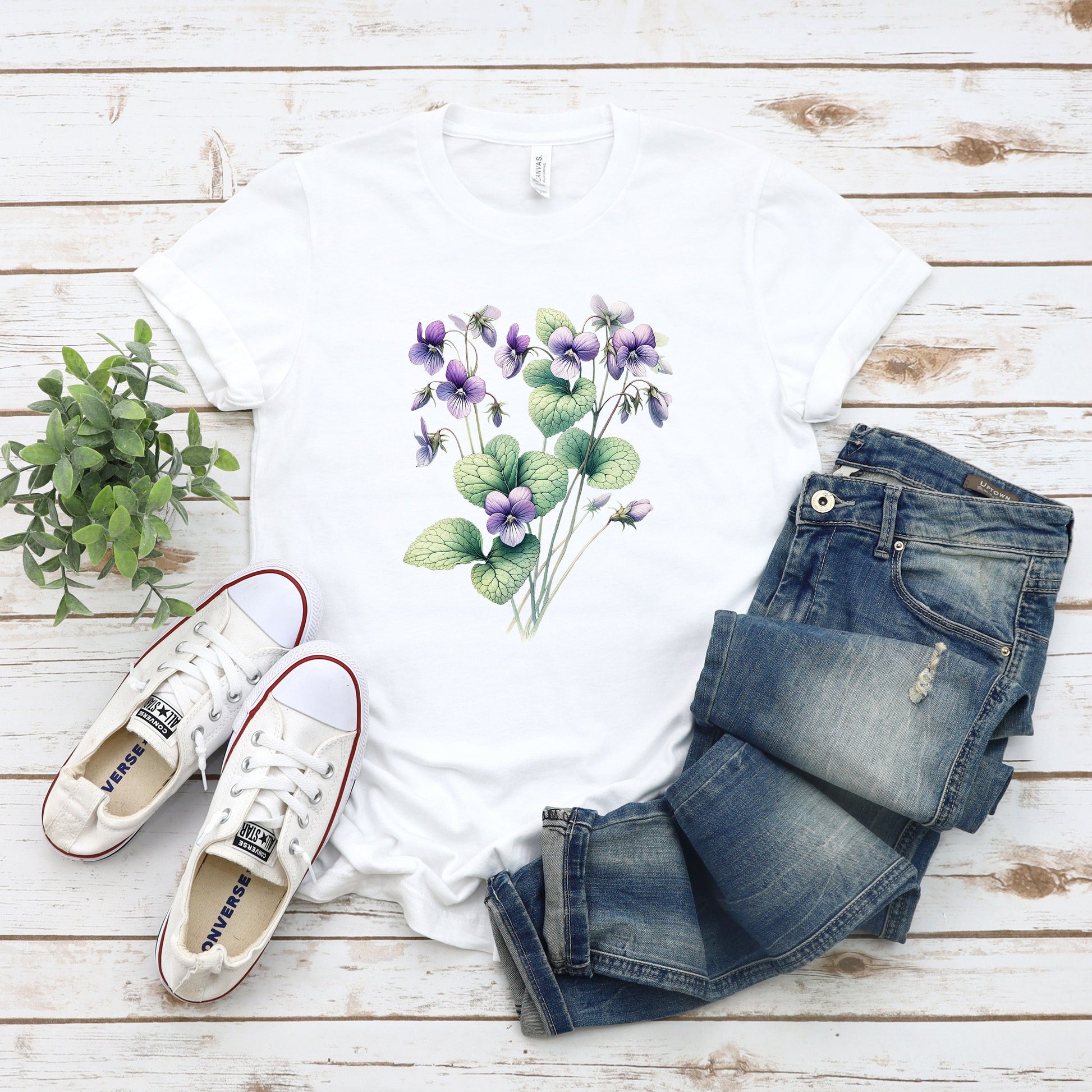 A t-shirt featuring a beautiful violet for February. Perfect for February birthdays and floral art lovers. Comfortable and stylish for casual outings or celebrations. Bella+Canvas 3001 t-shirt in white. ReadyShirtAim.com