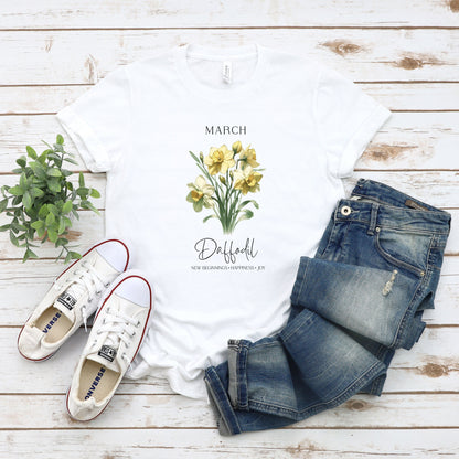 A t-shirt featuring a beautiful daffodil for March with traits New Beginnings, Happiness, Joy. Perfect for March birthdays and floral art lovers. Comfortable and stylish for casual outings or celebrations. Bella+Canvas 3001 t-shirt in white. ReadyShirtAim.com