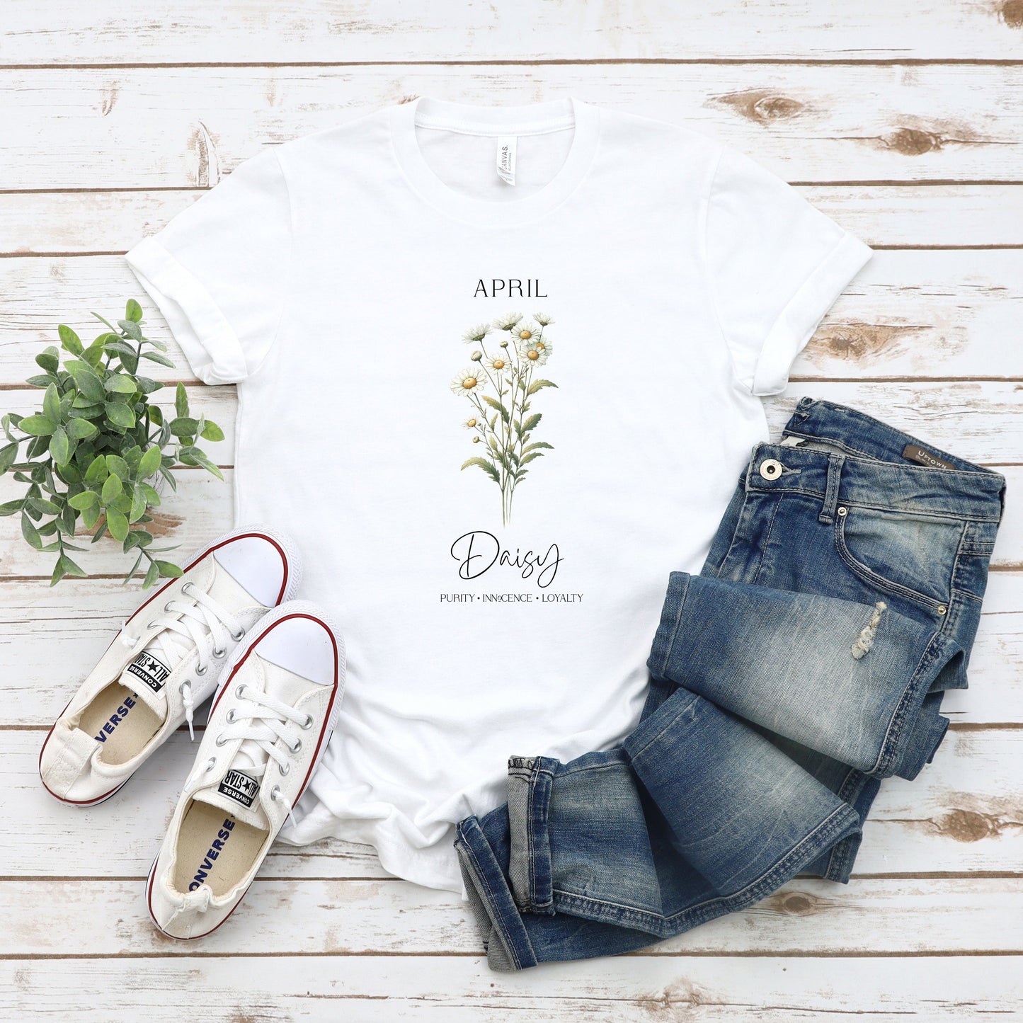 A t-shirt featuring a beautiful daisy for April with traits Purity, Innocence, Loyalty. Perfect for April birthdays and floral art lovers. Comfortable and stylish for casual outings or celebrations. Bella+Canvas 3001 t-shirt in white. ReadyShirtAim.com