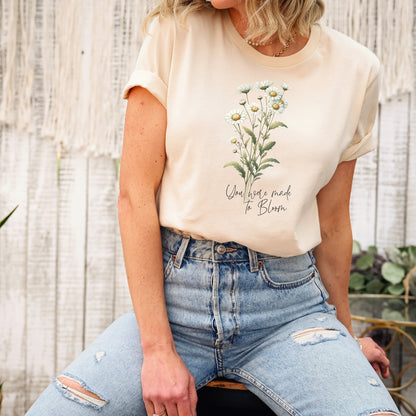 A t-shirt featuring a beautiful daisy for April with the quote “You were made to bloom.” Perfect for April birthdays and floral art lovers. Comfortable and stylish for casual outings or celebrations. Bella+Canvas 3001 t-shirt in soft cream. ReadyShirtAim.com