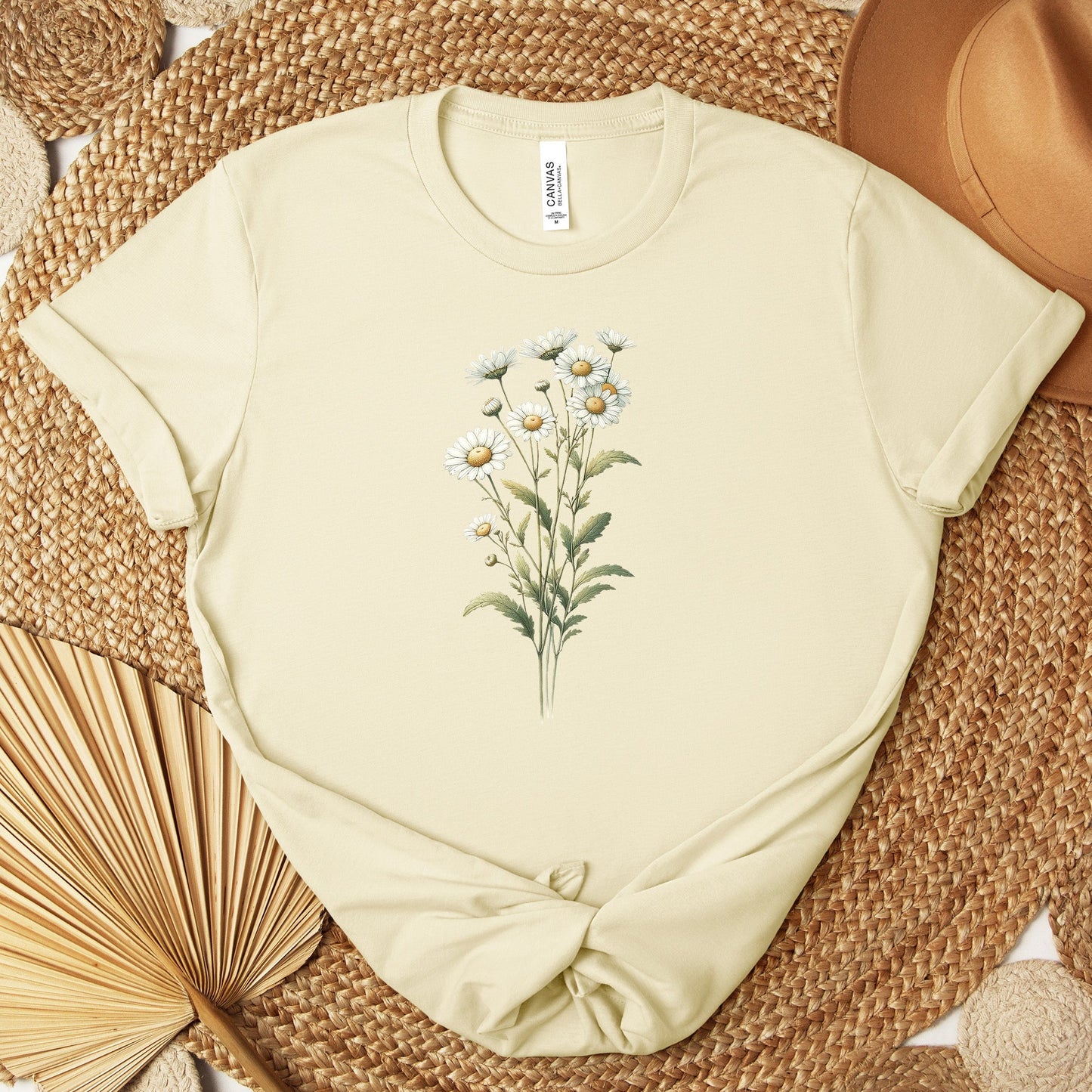 A t-shirt featuring a beautiful daisy for April. Perfect for April birthdays and floral art lovers. Comfortable and stylish for casual outings or celebrations. Bella+Canvas 3001 t-shirt in natural. ReadyShirtAim.com