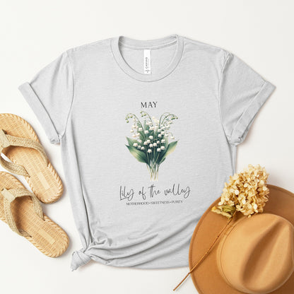 A t-shirt featuring a beautiful Lily of the Valley for May with traits Motherhood, Sweetness, Purity. Perfect for May birthdays and floral art lovers. Comfortable and stylish for casual outings or celebrations. Bella+Canvas 3001 t-shirt in ash. ReadyShirtAim.com