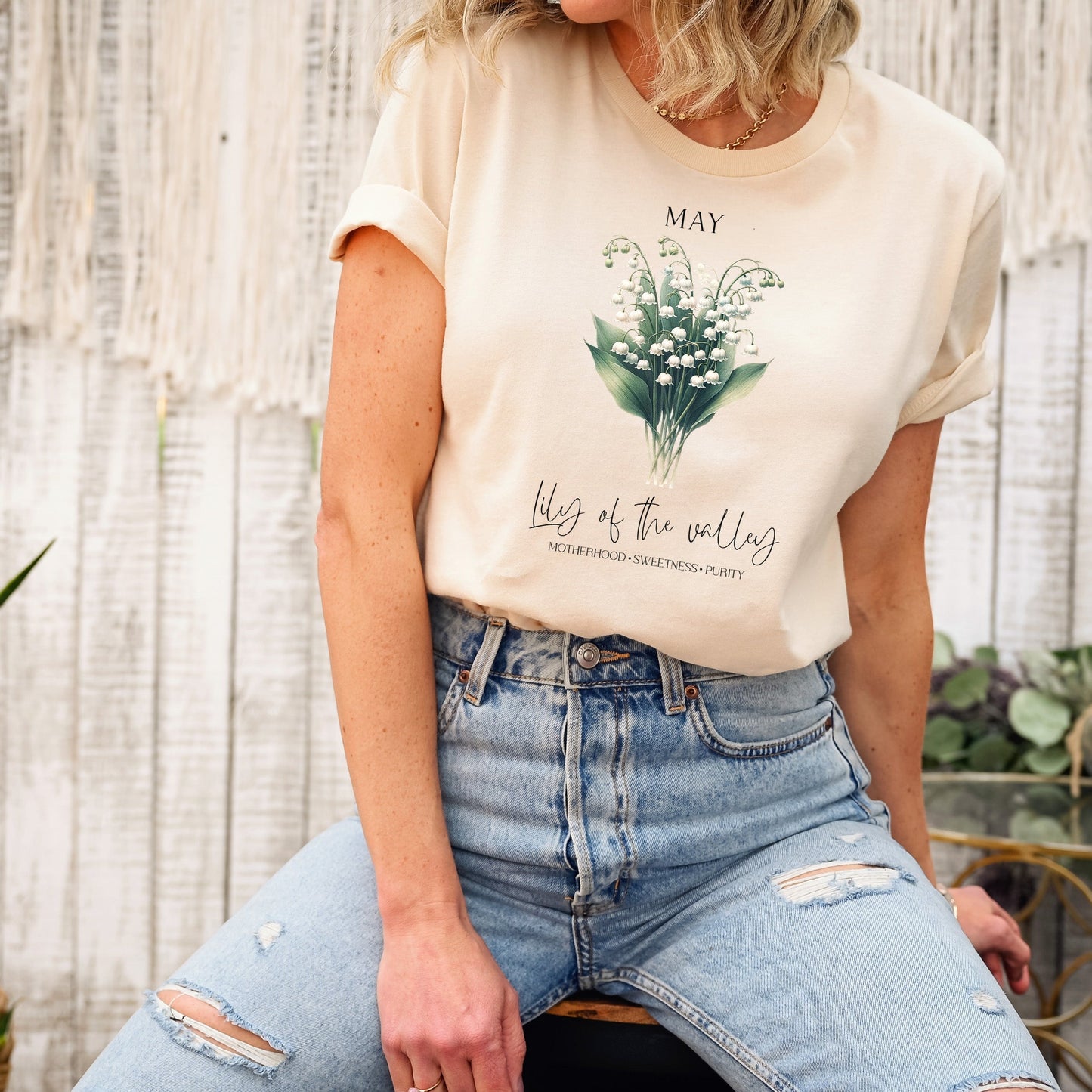 A t-shirt featuring a beautiful Lily of the Valley for May with traits Motherhood, Sweetness, Purity. Perfect for May birthdays and floral art lovers. Comfortable and stylish for casual outings or celebrations. Bella+Canvas 3001 t-shirt in soft cream. ReadyShirtAim.com