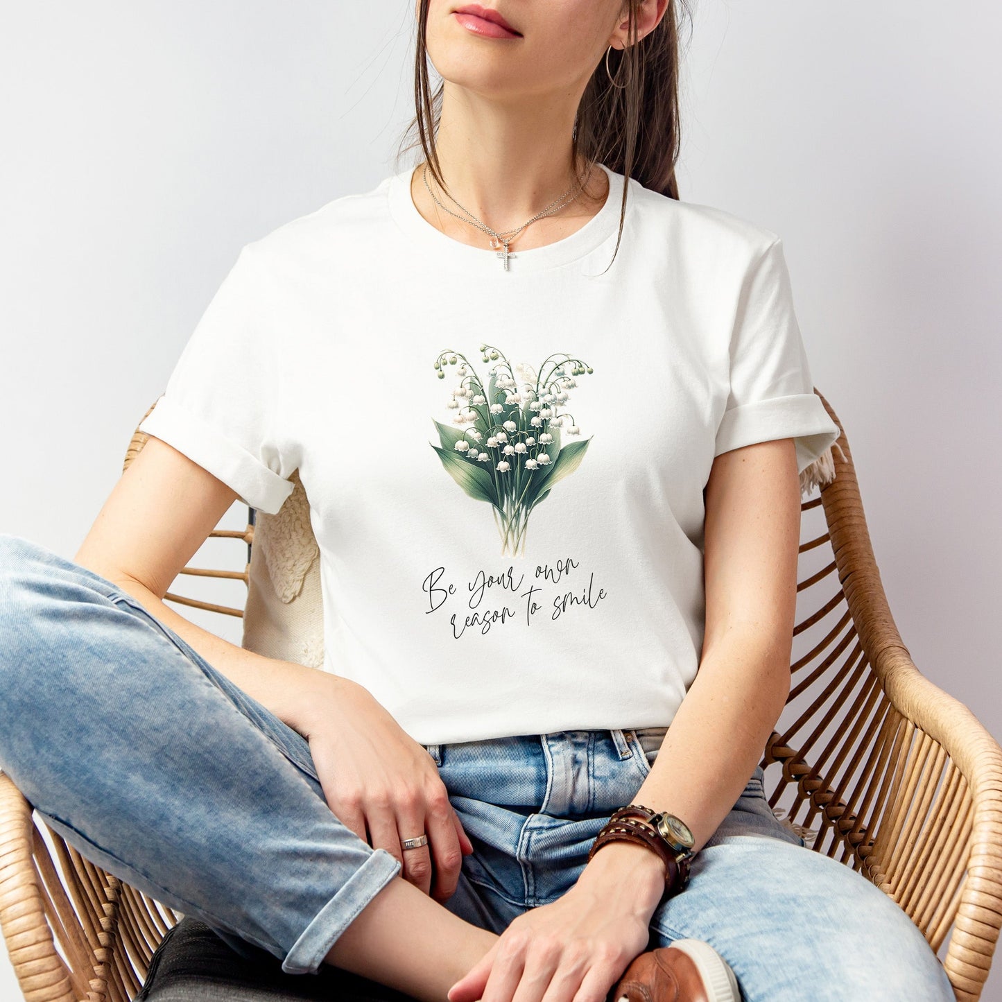 A t-shirt featuring a beautiful Lily of the Valley for May with the quote “Be your own reason to smile.” Perfect for May birthdays and floral art lovers. Comfortable and stylish for casual outings or celebrations. Bella+Canvas 3001 t-shirt in white. ReadyShirtAim.com