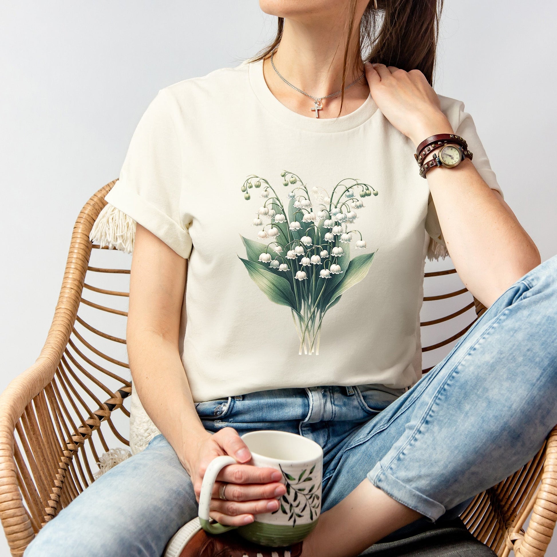 A t-shirt featuring a beautiful Lily of the Valley for May. Perfect for May birthdays and floral art lovers. Comfortable and stylish for casual outings or celebrations. Bella+Canvas 3001 t-shirt in natural. ReadyShirtAim.com