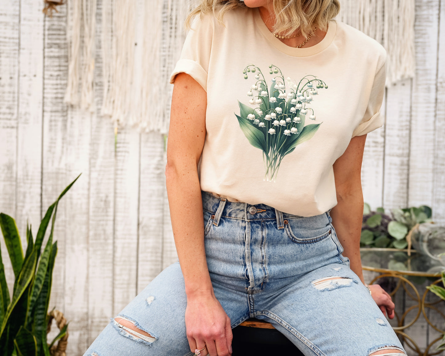 A t-shirt featuring a beautiful Lily of the Valley for May. Perfect for May birthdays and floral art lovers. Comfortable and stylish for casual outings or celebrations. Bella+Canvas 3001 t-shirt in soft cream. ReadyShirtAim.com