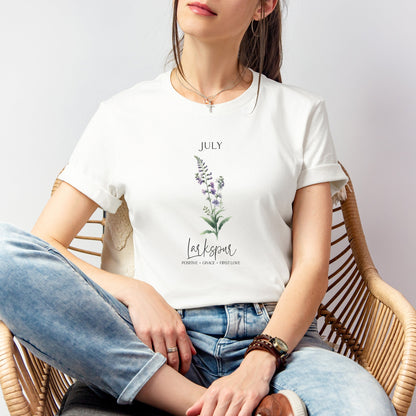 A t-shirt featuring a beautiful larkspur for July with traits Positive, Grace, First Love. Perfect for July birthdays and floral art lovers. Comfortable and stylish for casual outings or celebrations. Bella+Canvas 3001 t-shirt in white. ReadyShirtAim.com