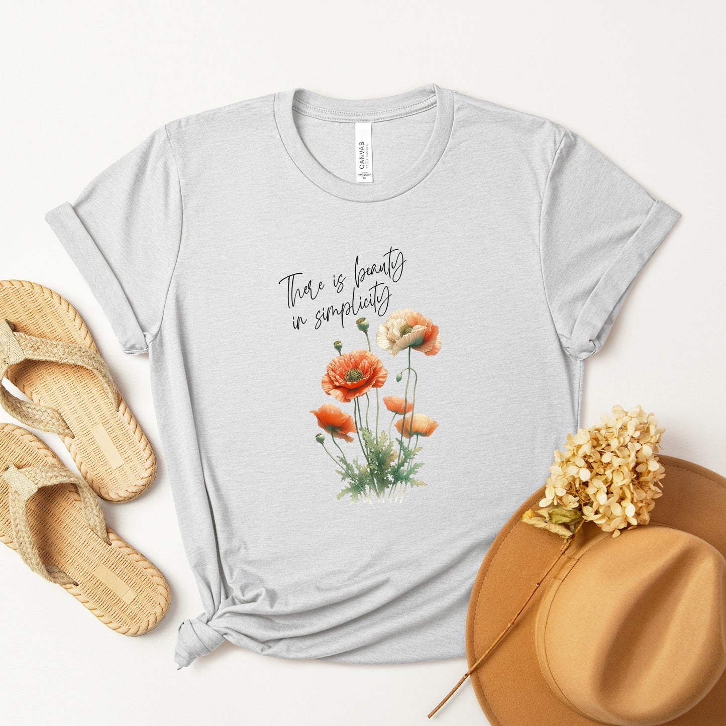 A t-shirt featuring a beautiful poppy for August with the quote “There is beauty in simplicity.” Perfect for August birthdays and floral art lovers. Comfortable and stylish for casual outings or celebrations. Bella+Canvas 3001 t-shirt in ash. ReadyShirtAim.com