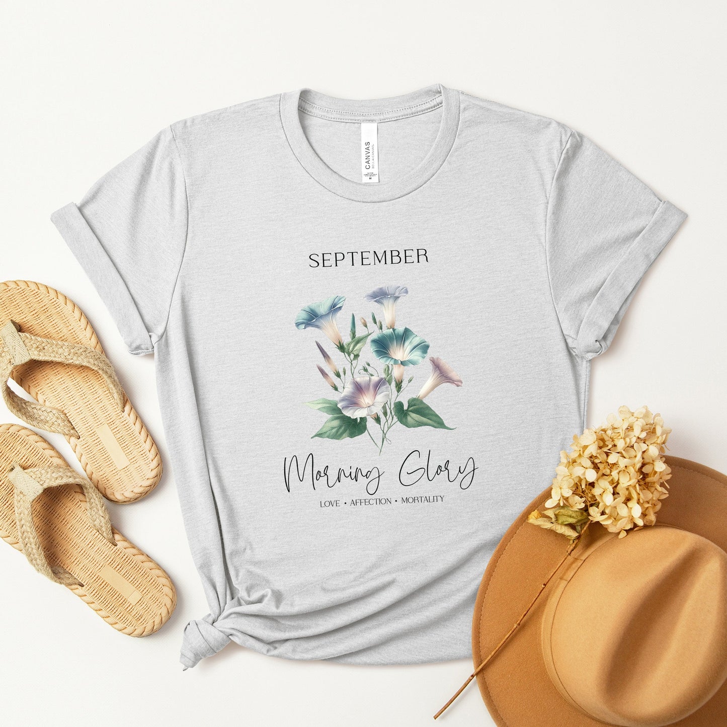 A t-shirt featuring a beautiful morning glory for September with traits Love, Affection, Mortality. Perfect for September birthdays and floral art lovers. Comfortable and stylish for casual outings or celebrations. Bella+Canvas 3001 t-shirt in ash. ReadyShirtAim.com