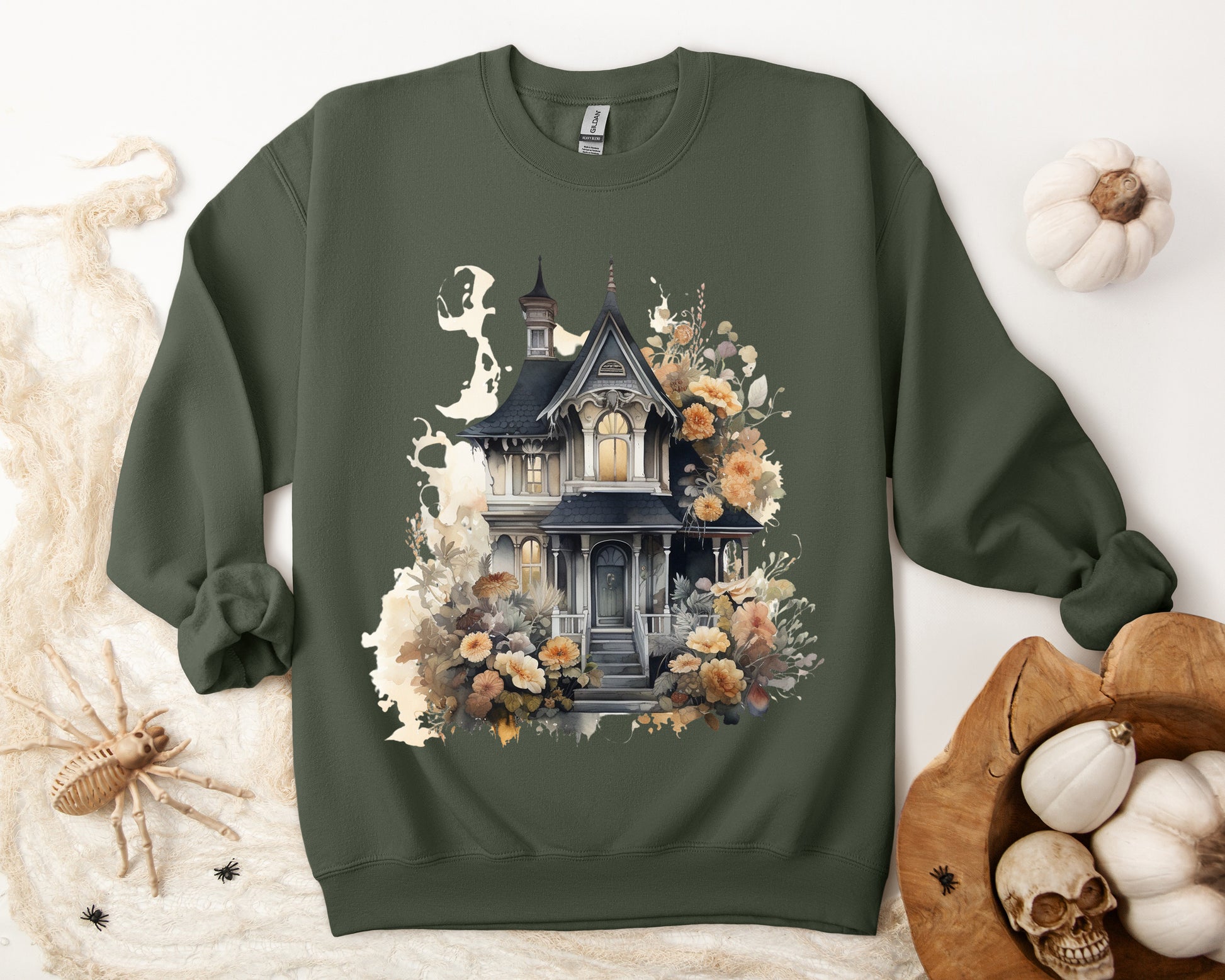 Halloween Boho Sweatshirt for Women featuring a haunted house illustration with boho design elements. Perfect for autumn festivities and casual wear. Gildan 18000 sweatshirt in Military Green. ReadyShirtAim.com