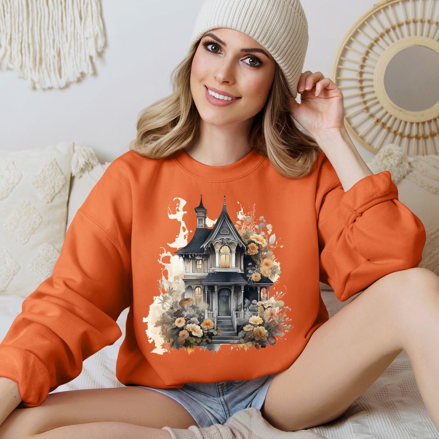 Halloween Boho Sweatshirt for Women featuring a haunted house illustration with boho design elements. Perfect for autumn festivities and casual wear. Available in multiple dark and light colors and sizes. Gildan 18000 sweatshirt in Orange. ReadyShirtAim.com