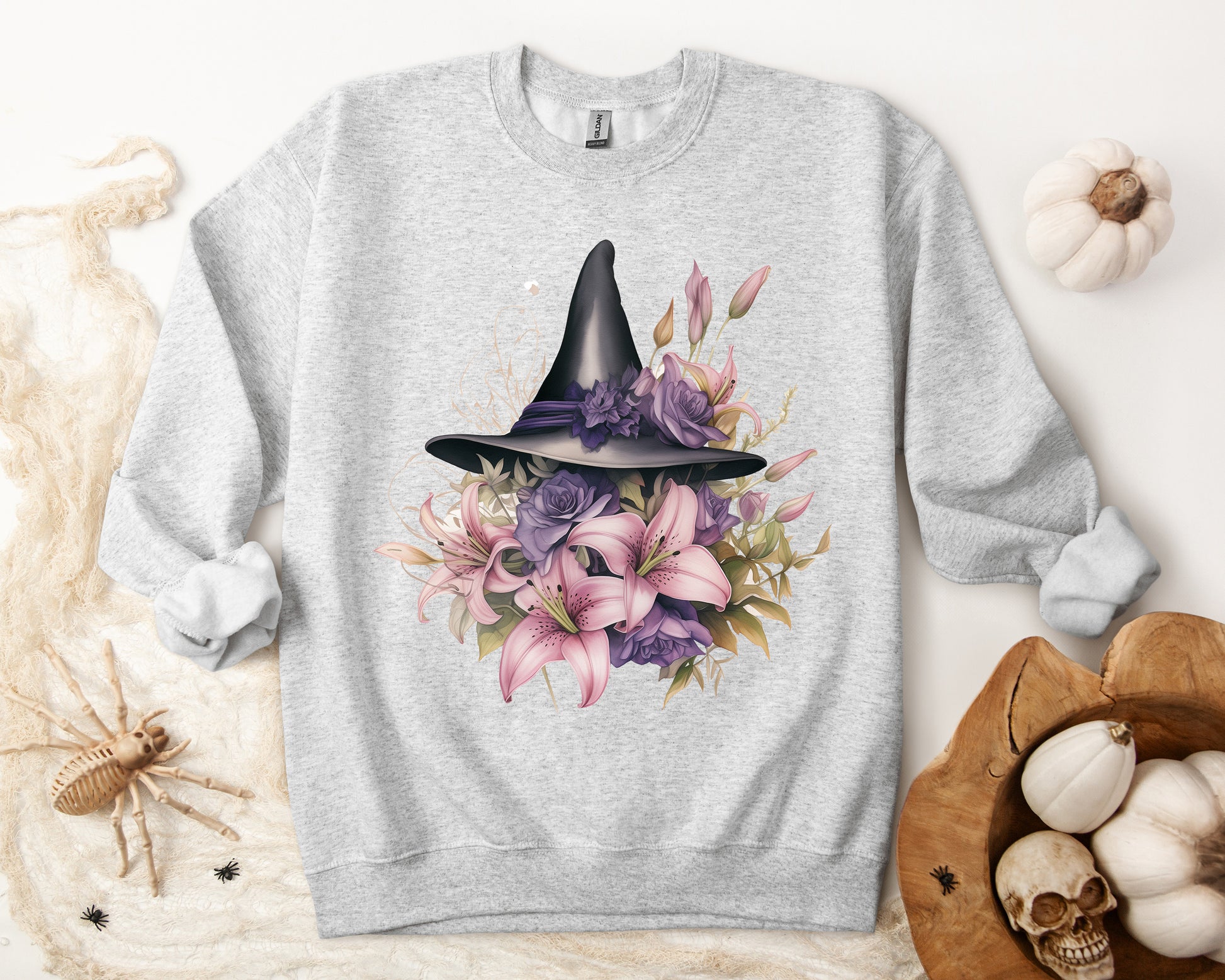 Enchanting Bohemian Witch Hat Sweatshirt with a watercolor illustration of a black witch hat surrounded by flowers in purple, pink, and green tones. Available in multiple dark ang light colors and sizes. Gildan 18000 sweatshirt in ash. ReadyShirtAim.com