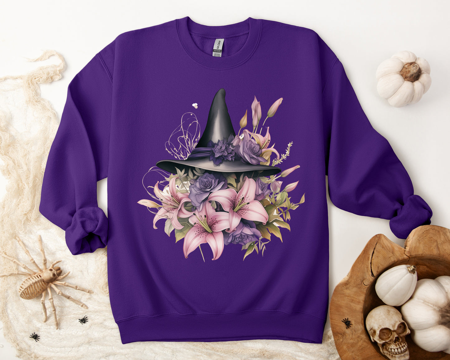 Enchanting Bohemian Witch Hat Sweatshirt with a watercolor illustration of a black witch hat surrounded by flowers in purple, pink, and green tones. Available in multiple dark ang light colors and sizes. Gildan 18000 sweatshirt in Purple. ReadyShirtAim.com