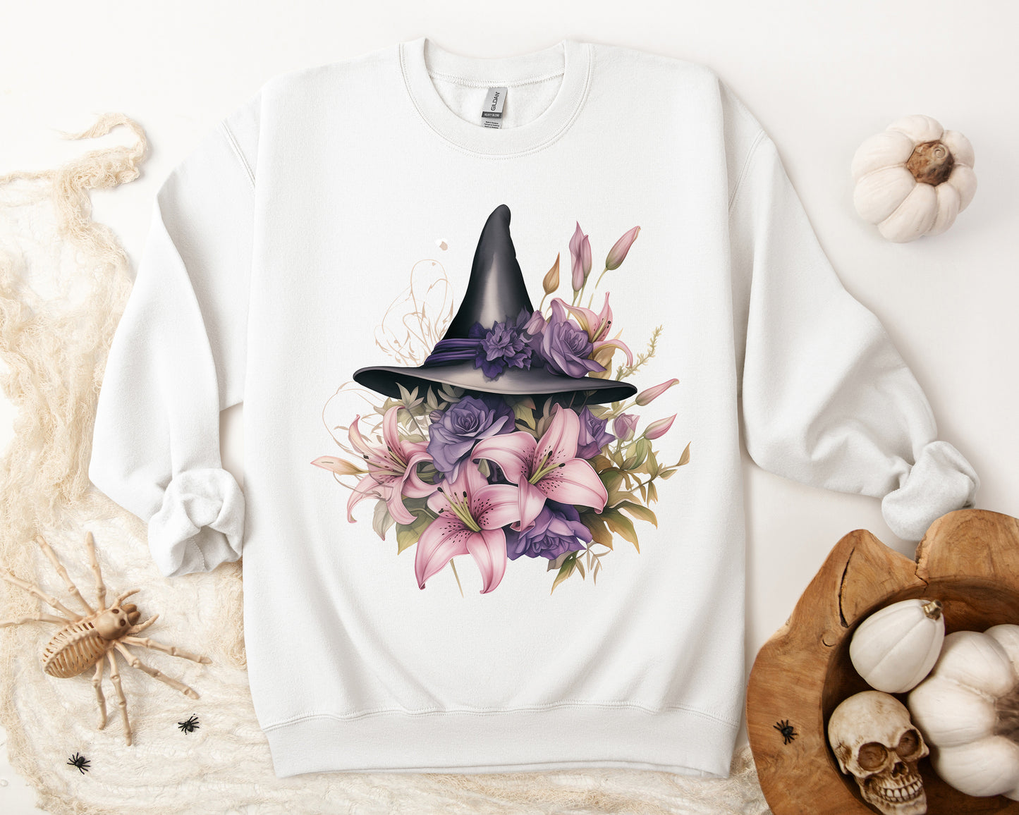 Enchanting Bohemian Witch Hat Sweatshirt with a watercolor illustration of a black witch hat surrounded by flowers in purple, pink, and green tones. Available in multiple dark ang light colors and sizes. Gildan 18000 sweatshirt in white. ReadyShirtAim.com