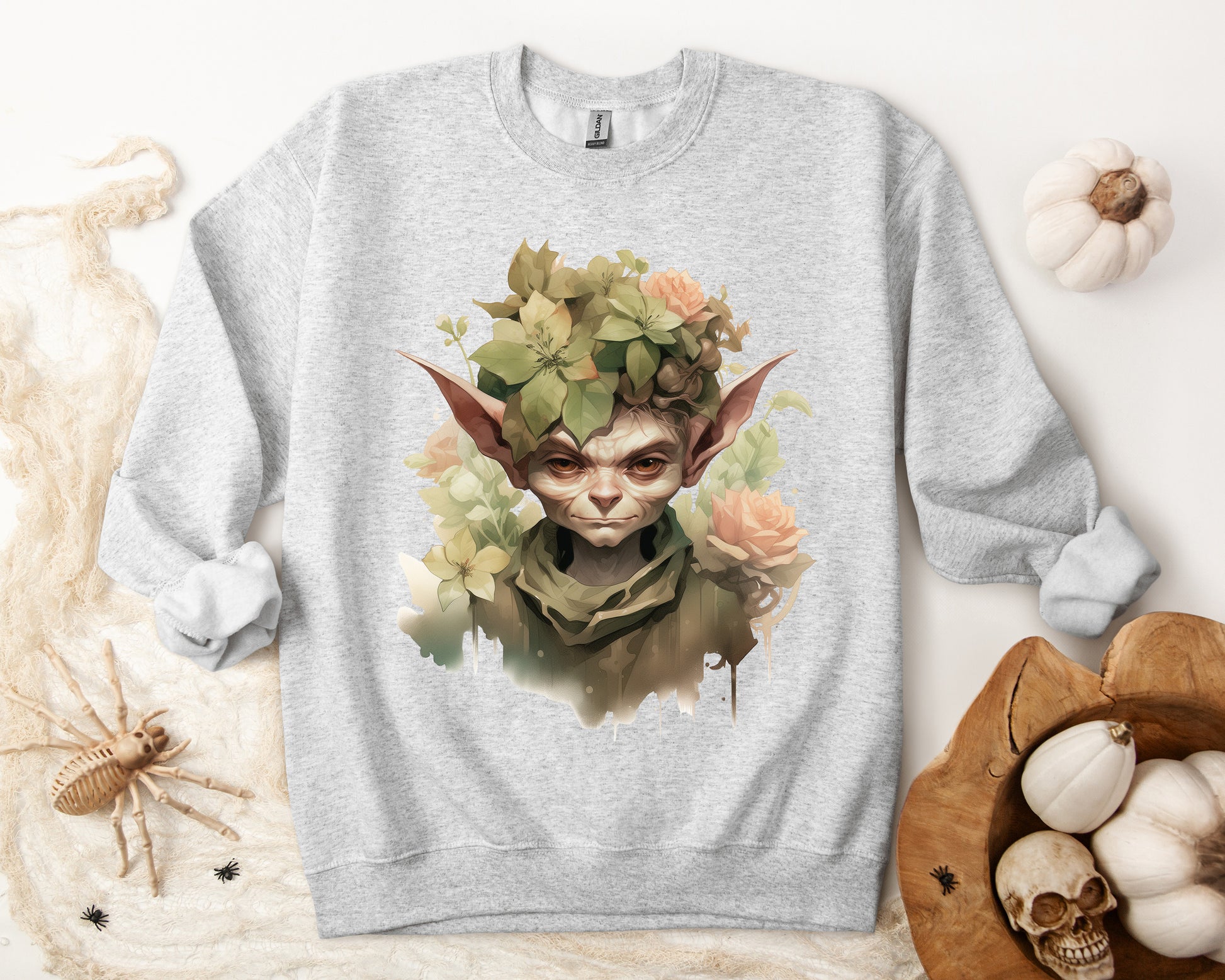 Whimsical Goblin & Floral Boho Halloween Sweatshirt for women. Features a charming goblin surrounded by delicate florals. Perfect for Halloween celebrations. Available in multiple dark and light colors and sizes. Gildan 18000 sweatshirt in ash. ReadyShirtAim.com