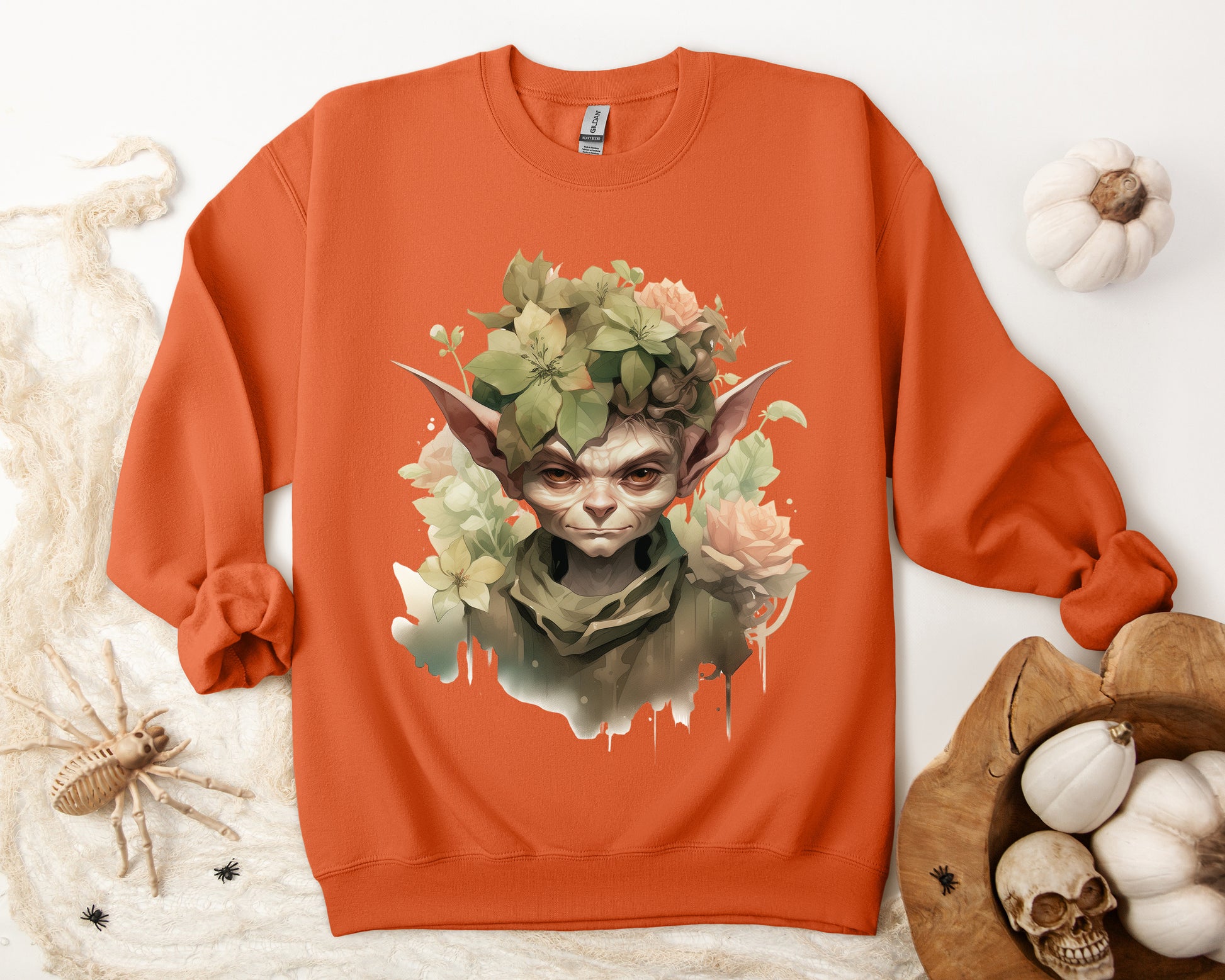 Whimsical Goblin & Floral Boho Halloween Sweatshirt for women. Features a charming goblin surrounded by delicate florals. Perfect for Halloween celebrations. Available in multiple dark and light colors and sizes. Gildan 18000 sweatshirt in Orange. ReadyShirtAim.com