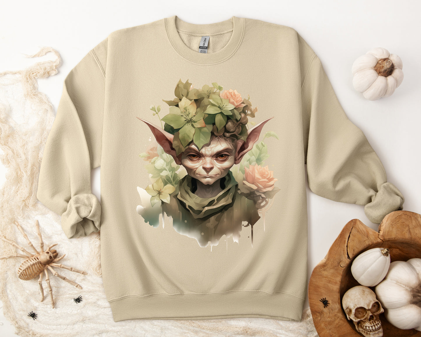 Whimsical Goblin & Floral Boho Halloween Sweatshirt for women. Features a charming goblin surrounded by delicate florals. Perfect for Halloween celebrations. Available in multiple dark and light colors and sizes. Gildan 18000 sweatshirt in Sand. ReadyShirtAim.com