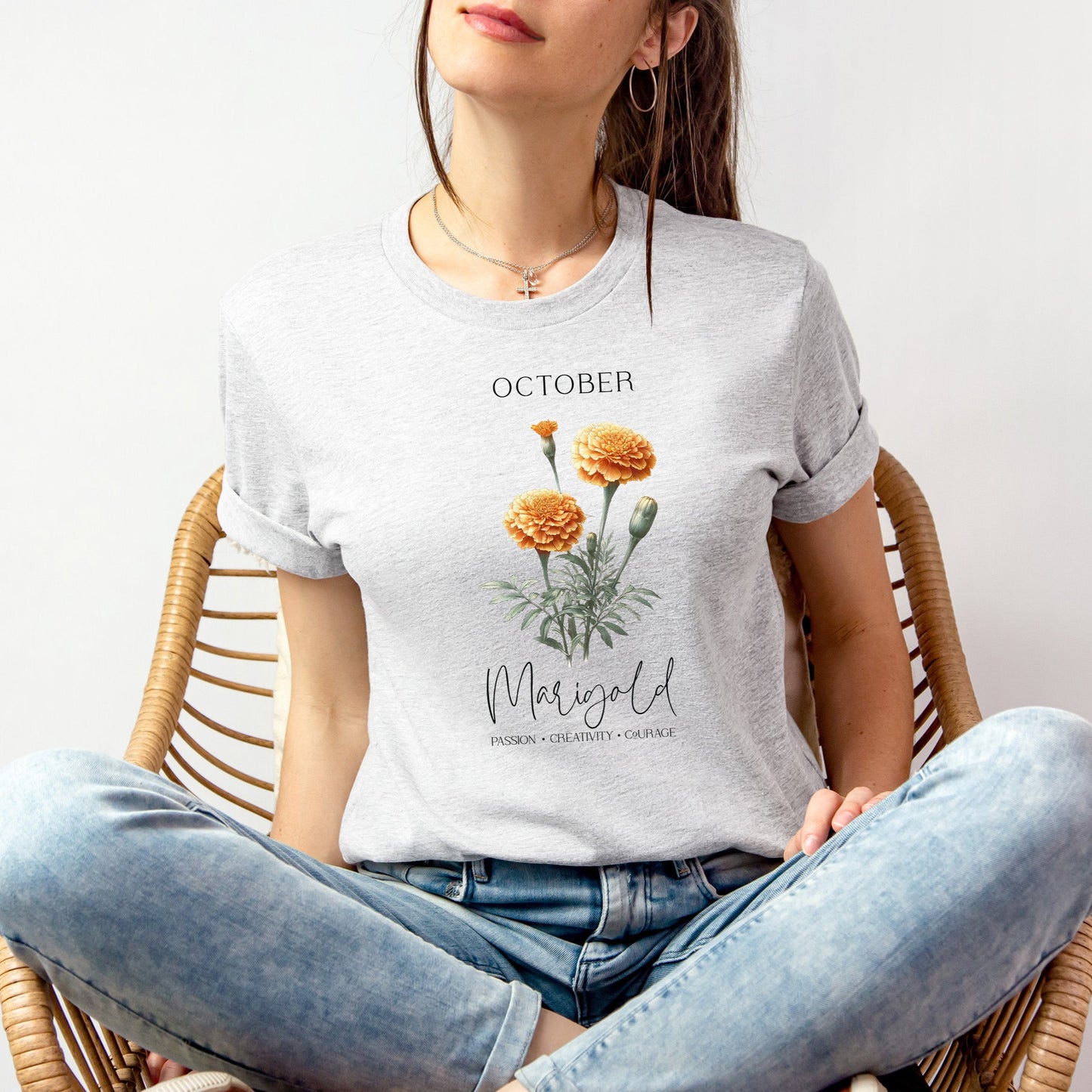 A t-shirt featuring a beautiful marigold for October with traits Passion, Creativity, Courage. Perfect for October birthdays and floral art lovers. Comfortable and stylish for casual outings or celebrations. Bella+Canvas 3001 t-shirt in ash. ReadyShirtAim.com