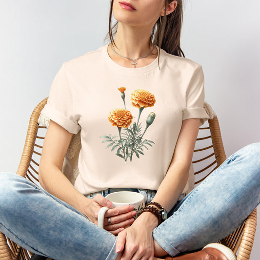 A t-shirt featuring a beautiful marigold for October. Perfect for October birthdays and floral art lovers. Comfortable and stylish for casual outings or celebrations. Bella+Canvas 3001 t-shirt in soft cream. ReadyShirtAim.com