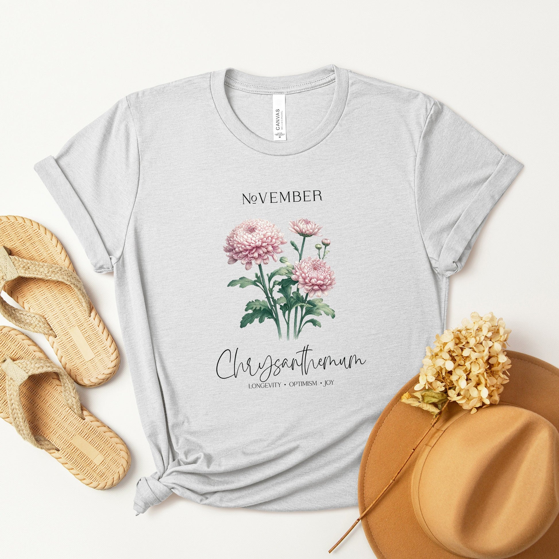 A t-shirt featuring a beautiful chrysanthemum for November with traits Longevity, Optimism, Joy. Perfect for November birthdays and floral art lovers. Comfortable and stylish for casual outings or celebrations. Bella+Canvas 3001 t-shirt in ash. ReadyShirtAim.com