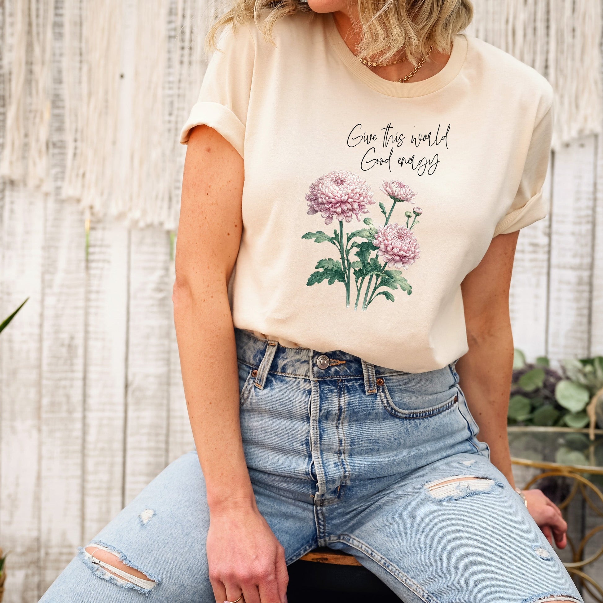 A t-shirt featuring a beautiful chrysanthemum for November with the quote “Give this world good energy.” Perfect for November birthdays and floral art lovers. Comfortable and stylish for casual outings or celebrations. Bella+Canvas 3001 t-shirt in soft cream. ReadyShirtAim.com