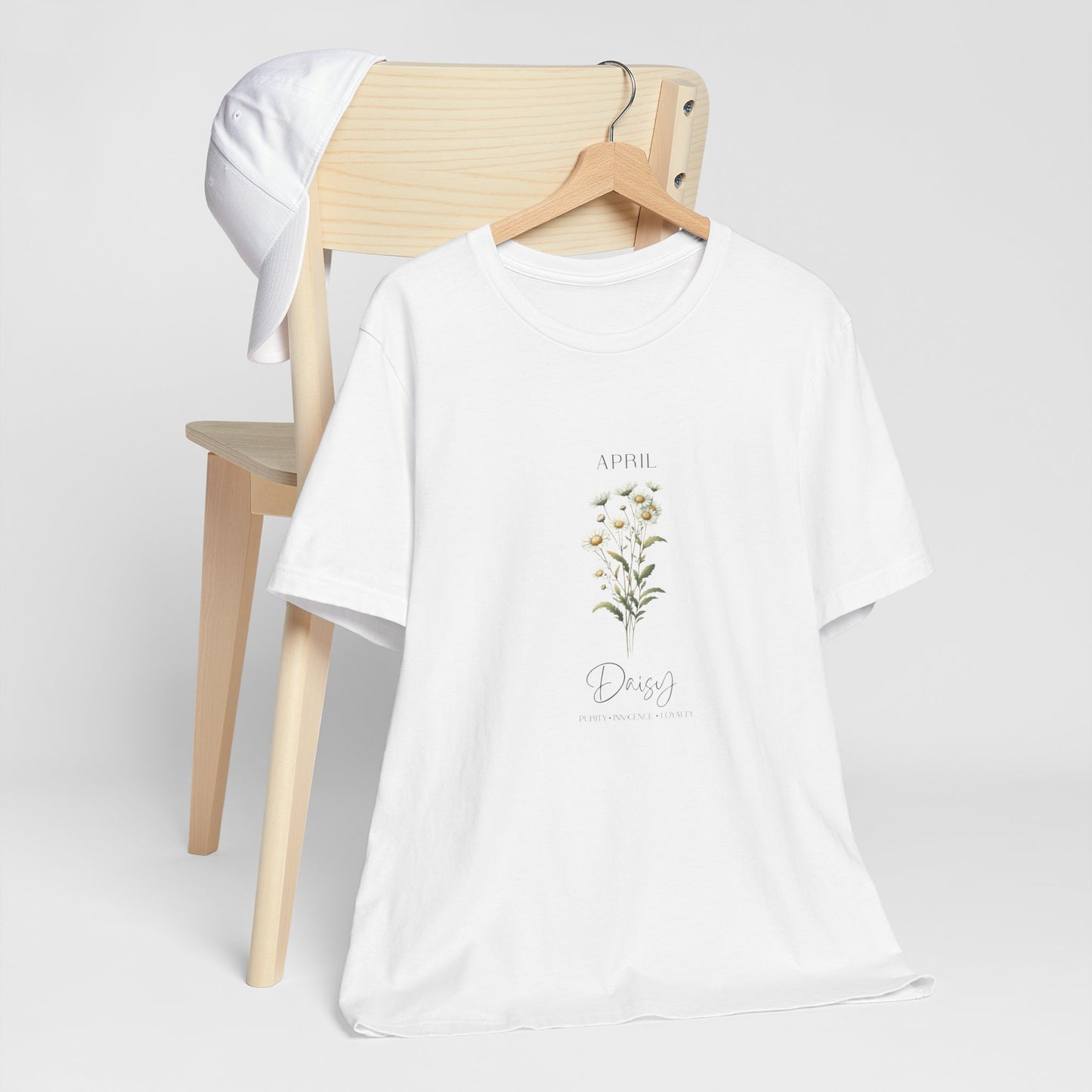 A t-shirt featuring a beautiful daisy for April with traits Purity, Innocence, Loyalty. Perfect for April birthdays and floral art lovers. Comfortable and stylish for casual outings or celebrations. Bella+Canvas 3001 t-shirt in white. ReadyShirtAim.com