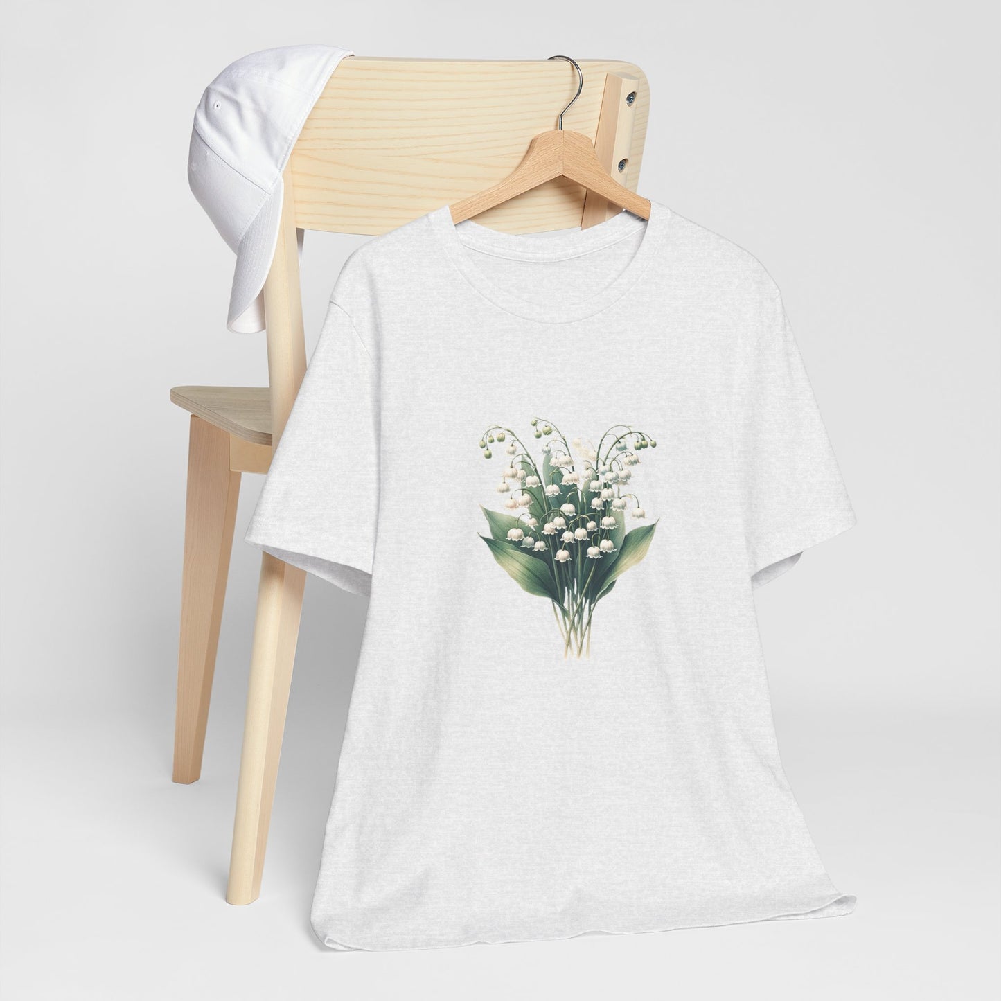 A t-shirt featuring a beautiful Lily of the Valley for May. Perfect for May birthdays and floral art lovers. Comfortable and stylish for casual outings or celebrations. Bella+Canvas 3001 t-shirt in ash. ReadyShirtAim.com