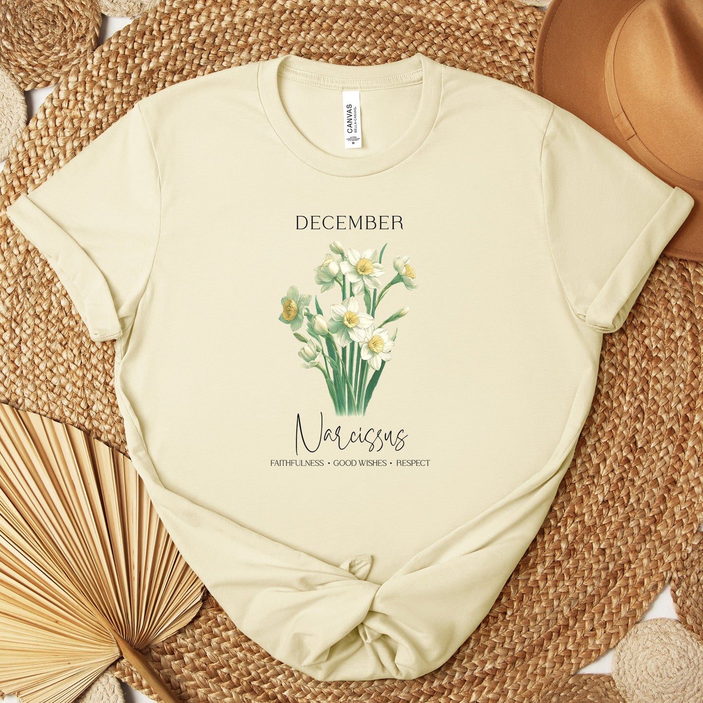 AA t-shirt featuring a beautiful narcissus for December with traits Faithfulness, Good Wishes, Respect. Perfect for December birthdays and floral art lovers. Comfortable and stylish for casual outings or celebrations. Bella+Canvas 3001 t-shirt in natural. ReadyShirtAim.com