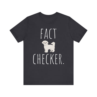 "Fact Checker" Maltese Dog T-Shirt for Unisex with a cute graphic of a Maltese dog and playful "Fact Checker" text underneath. Ideal for dog lovers. Ideal for dog lovers with a sense of humor. Available in multiple colors and sizes. Bella+Canvas 3001 t-shirt in dark grey. ReadyShirtAim.com