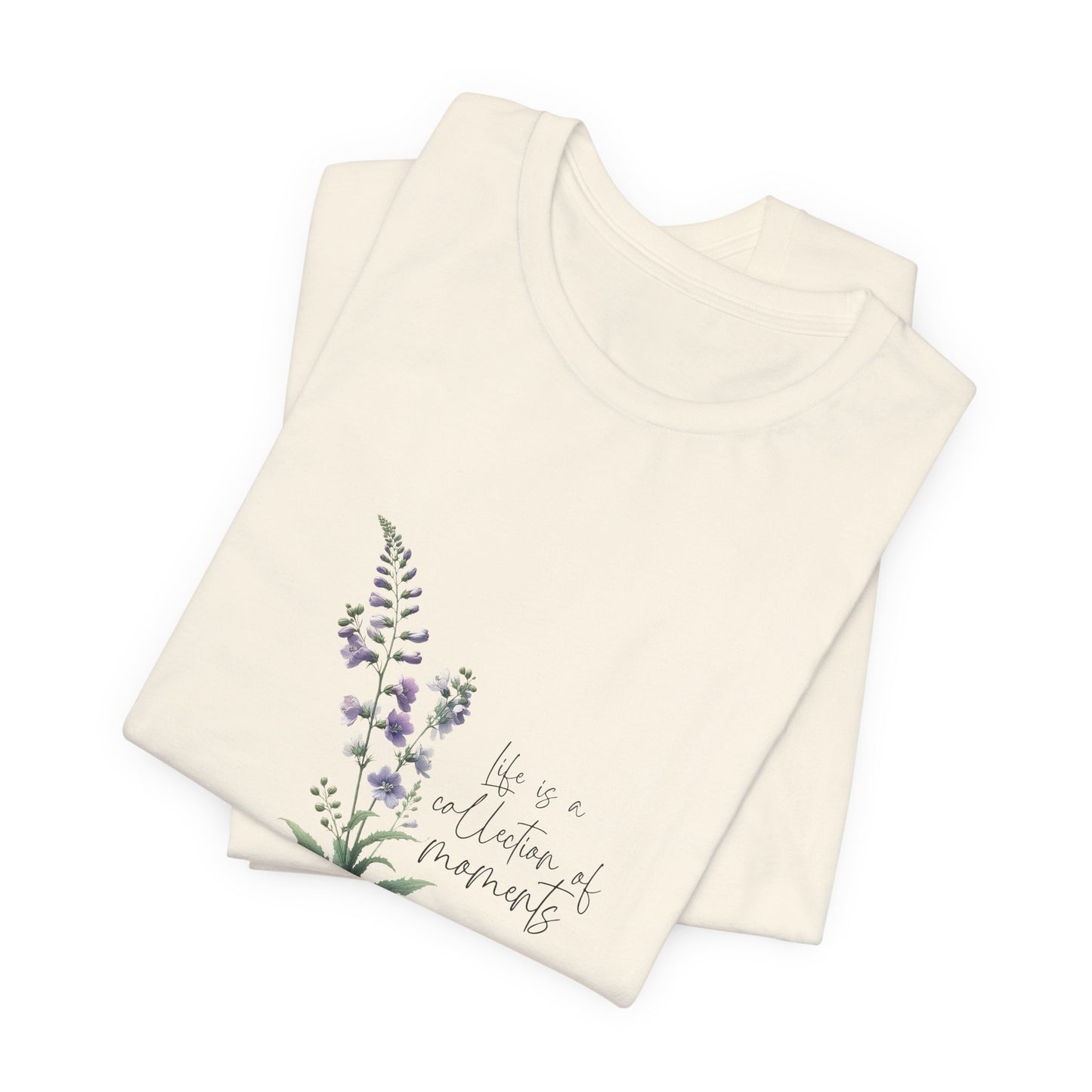 A t-shirt featuring a beautiful larkspur for July with the quote “Life is a collection of moments.” Perfect for July birthdays and floral art lovers. Comfortable and stylish for casual outings or celebrations. Bella+Canvas 3001 t-shirt in natural. ReadyShirtAim.com