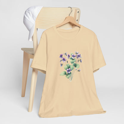 A t-shirt featuring a beautiful violet for February. Perfect for February birthdays and floral art lovers. Comfortable and stylish for casual outings or celebrations. Bella+Canvas 3001 t-shirt in soft cream. ReadyShirtAim.com