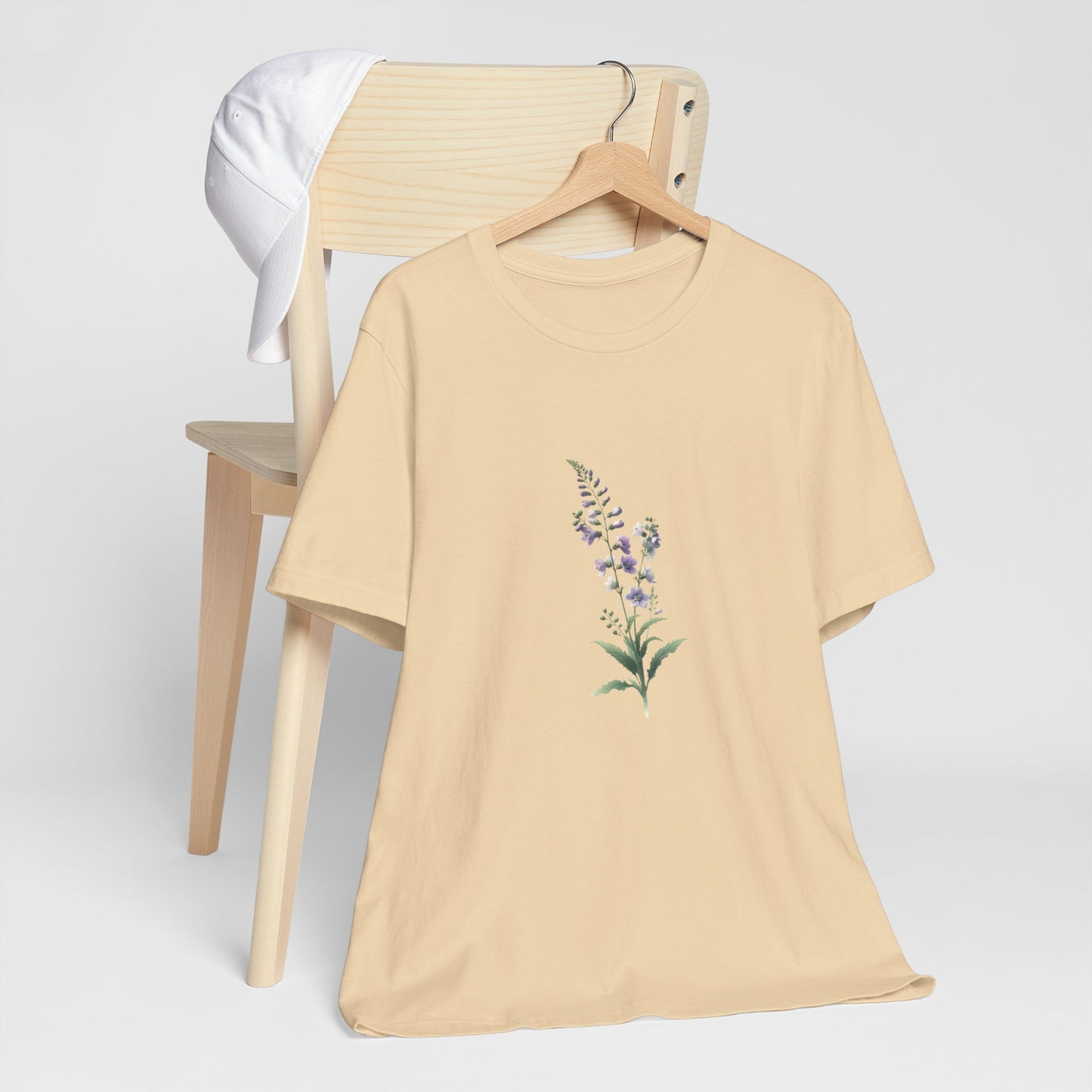 A t-shirt featuring a beautiful larkspur for July. Perfect for July birthdays and floral art lovers. Comfortable and stylish for casual outings or celebrations. Bella+Canvas 3001 t-shirt in soft cream. ReadyShirtAim.com