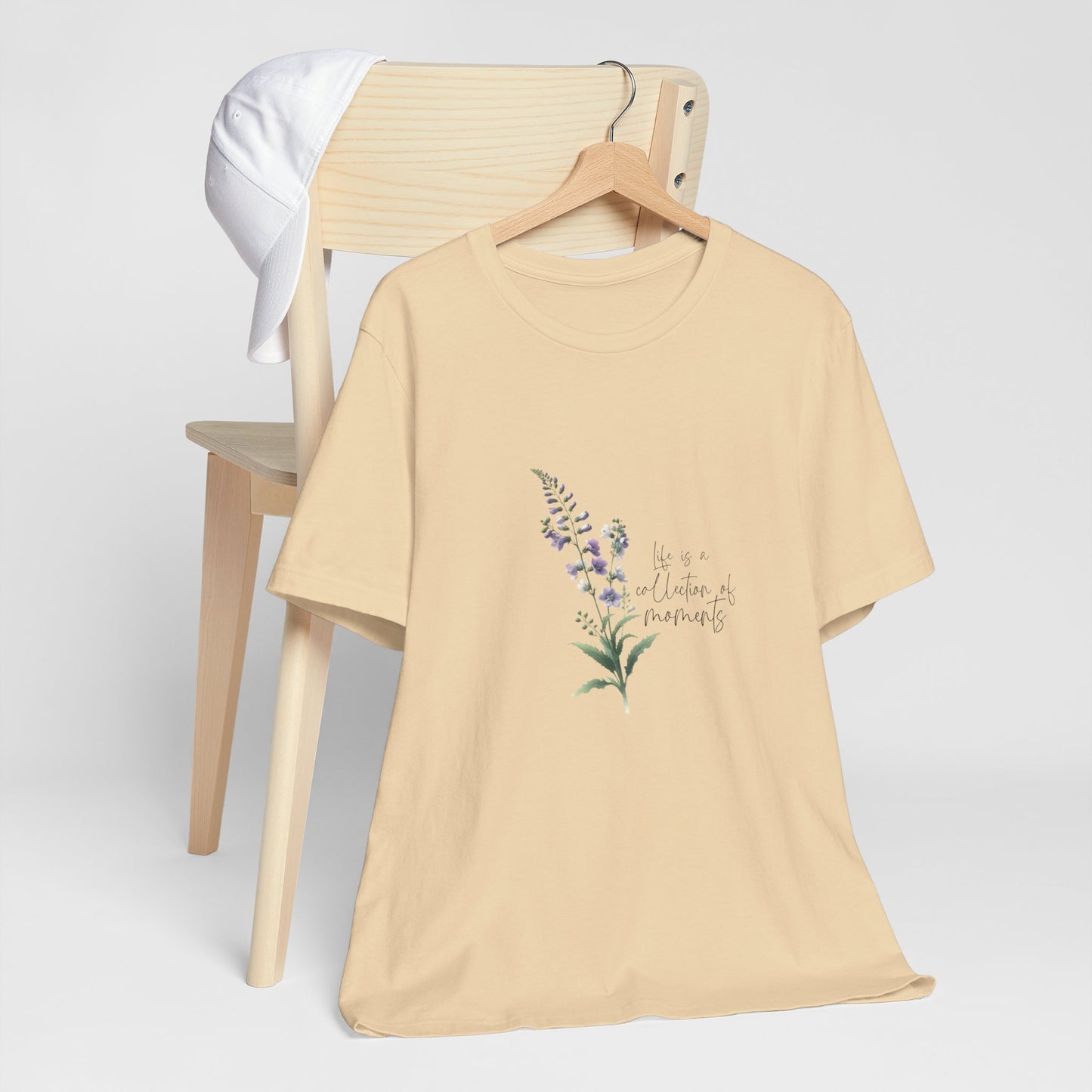 A t-shirt featuring a beautiful larkspur for July with the quote “Life is a collection of moments.” Perfect for July birthdays and floral art lovers. Comfortable and stylish for casual outings or celebrations. Bella+Canvas 3001 t-shirt in soft cream. ReadyShirtAim.com