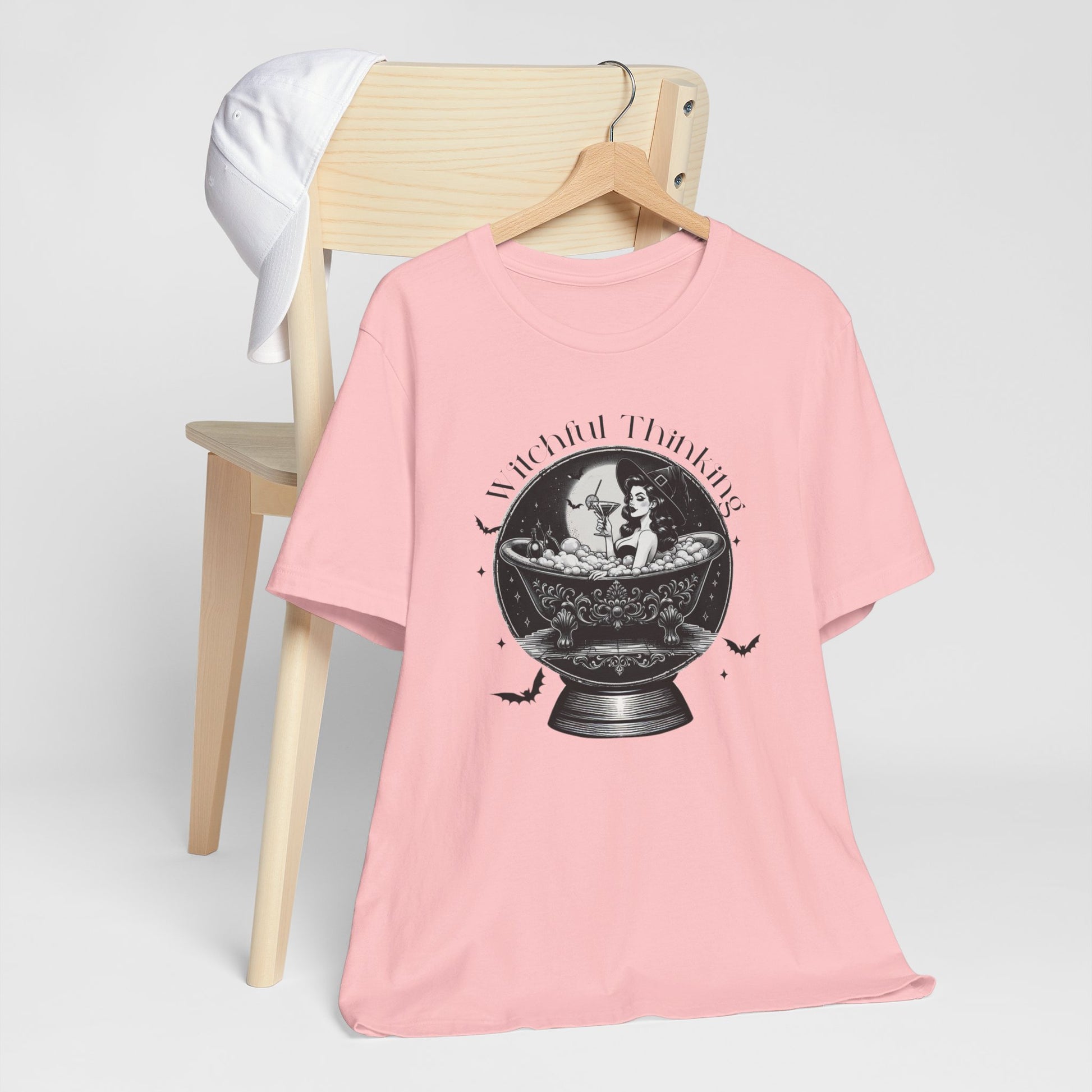 "Witchful Thinking" Vintage 1950's Witch Halloween Women's T-Shirt featuring black text and classic black-and-white pin-up girl images, perfect for adding a retro touch to your Halloween festivities. Available in multiple colors and sizes.  Bella+Canvas 3001 t-shirt in pink. ReadyShirtAim.com