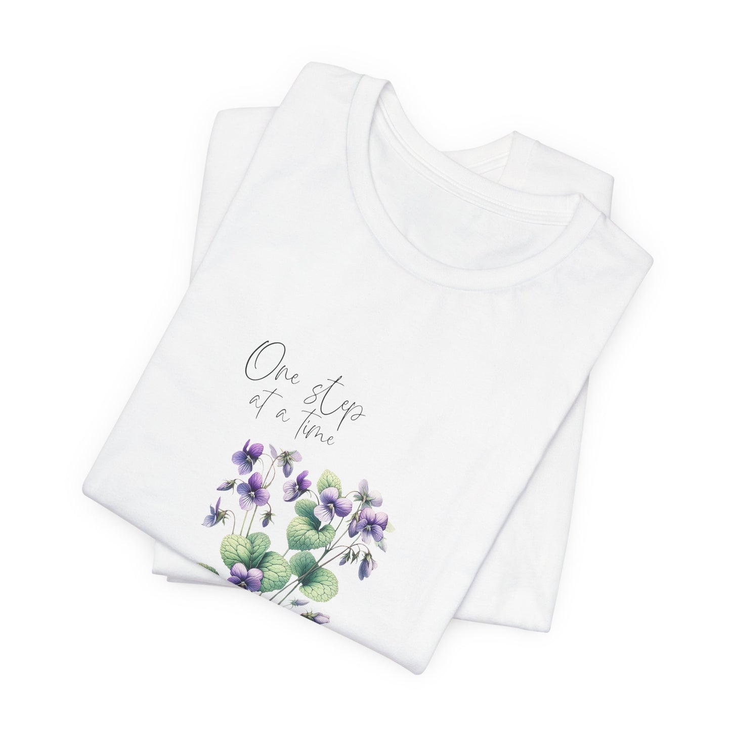 A t-shirt featuring a beautiful violet for February with the quote “One step at a time.” Perfect for February birthdays and floral art lovers. Comfortable and stylish for casual outings or celebrations. Bella+Canvas 3001 t-shirt in white. ReadyShirtAim.com