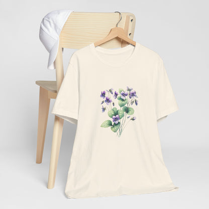 A t-shirt featuring a beautiful violet for February. Perfect for February birthdays and floral art lovers. Comfortable and stylish for casual outings or celebrations. Bella+Canvas 3001 t-shirt in natural. ReadyShirtAim.com