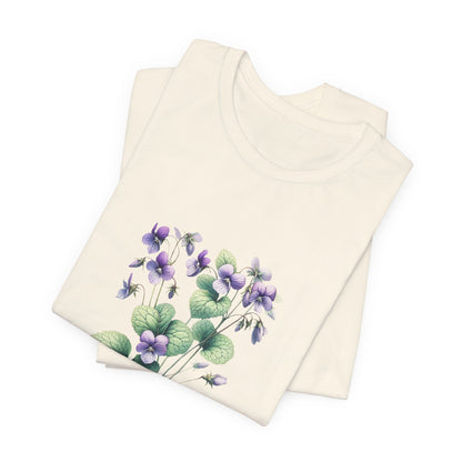 A t-shirt featuring a beautiful violet for February. Perfect for February birthdays and floral art lovers. Comfortable and stylish for casual outings or celebrations. Bella+Canvas 3001 t-shirt in natural. ReadyShirtAim.com