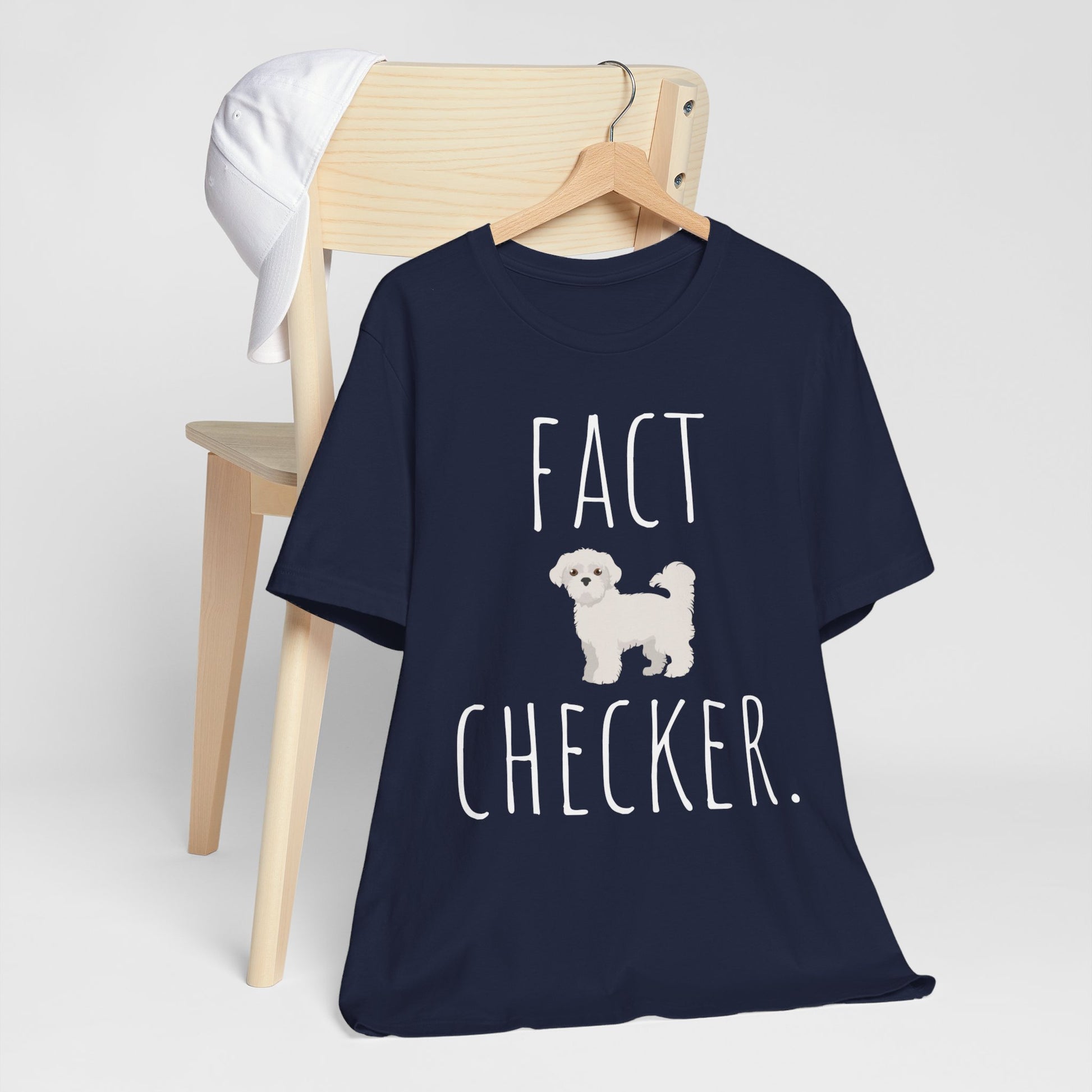 "Fact Checker" Maltese Dog T-Shirt for Unisex with a cute graphic of a Maltese dog and playful "Fact Checker" text underneath. Ideal for dog lovers. Ideal for dog lovers with a sense of humor. Bella+Canvas 3001 t-shirt in navy. ReadyShirtAim.com