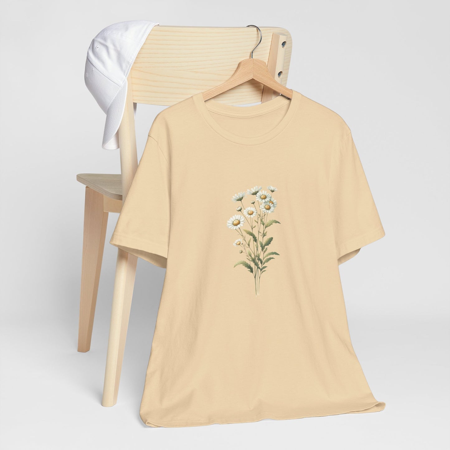 A t-shirt featuring a beautiful daisy for April. Perfect for April birthdays and floral art lovers. Comfortable and stylish for casual outings or celebrations. Bella+Canvas 3001 t-shirt in soft cream. ReadyShirtAim.com