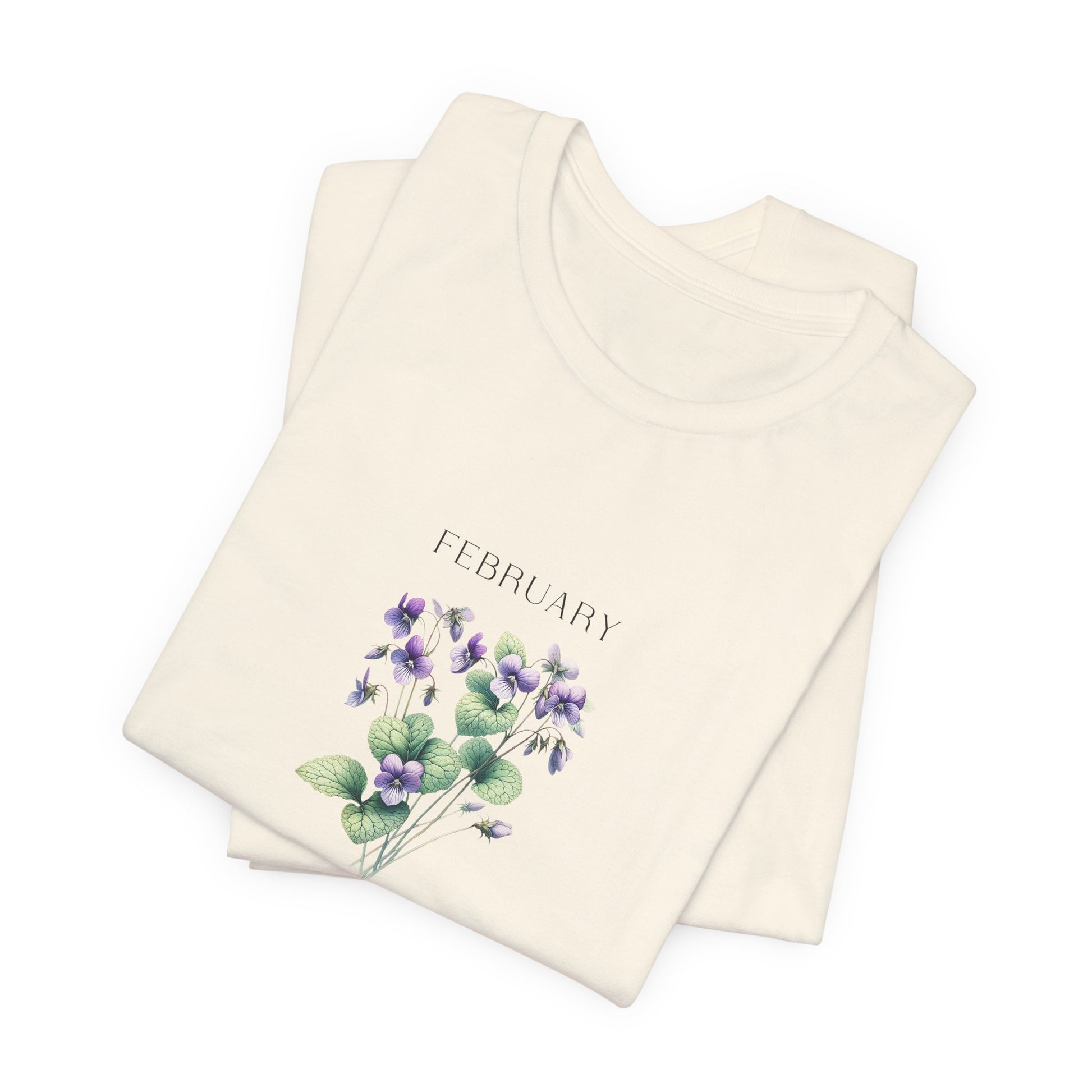 A t-shirt featuring a beautiful violet for February with traits Virtue, Modesty, Humility. Perfect for February birthdays and floral art lovers. Comfortable and stylish for casual outings or celebrations. Bella+Canvas 3001 t-shirt in natural. ReadyShirtAim.com