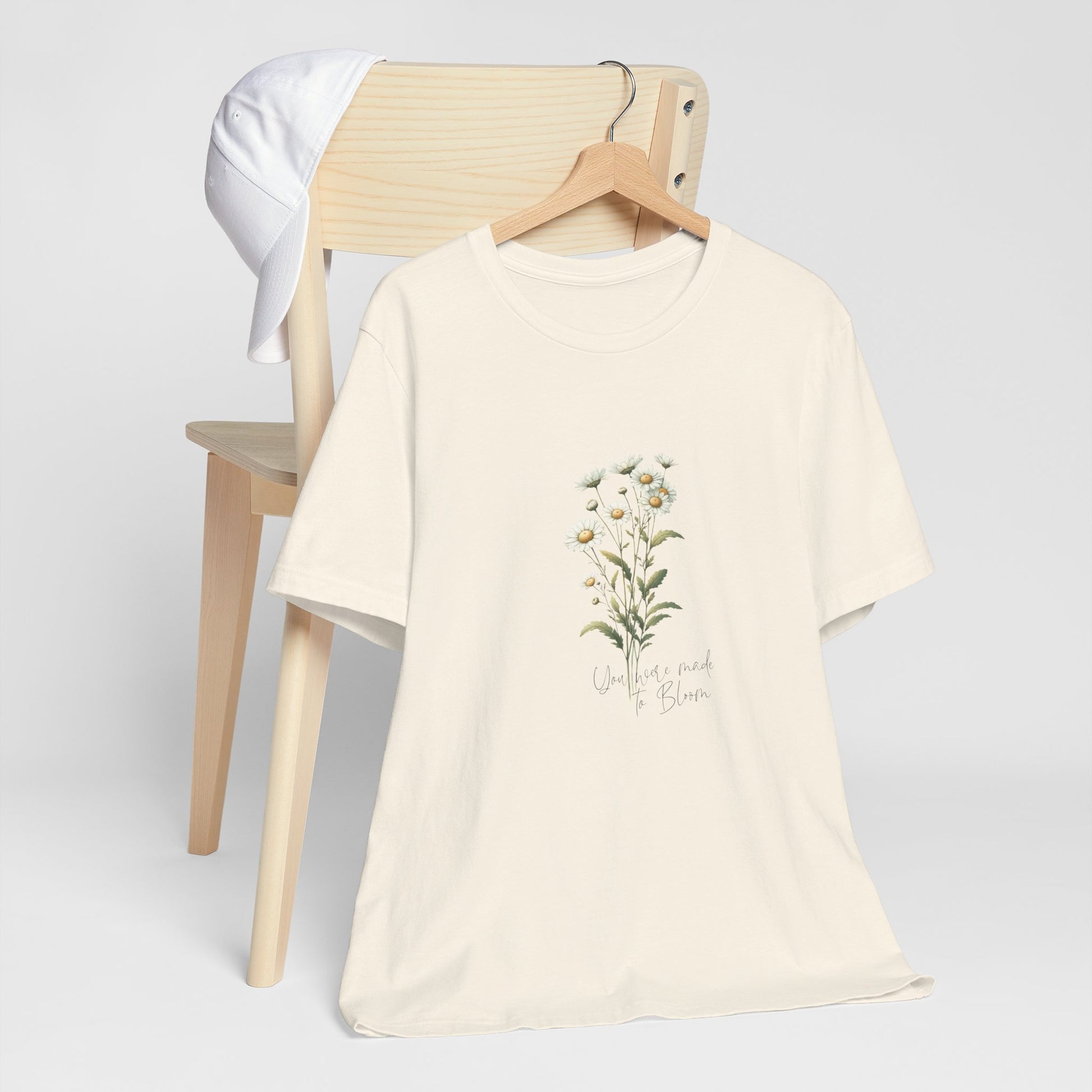 A t-shirt featuring a beautiful daisy for April with the quote “You were made to bloom.” Perfect for April birthdays and floral art lovers. Comfortable and stylish for casual outings or celebrations. Bella+Canvas 3001 t-shirt in natural. ReadyShirtAim.com