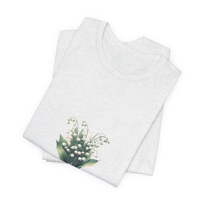 A t-shirt featuring a beautiful Lily of the Valley for May with the quote “Be your own reason to smile.” Perfect for May birthdays and floral art lovers. Comfortable and stylish for casual outings or celebrations. Bella+Canvas 3001 t-shirt in ash. ReadyShirtAim.com